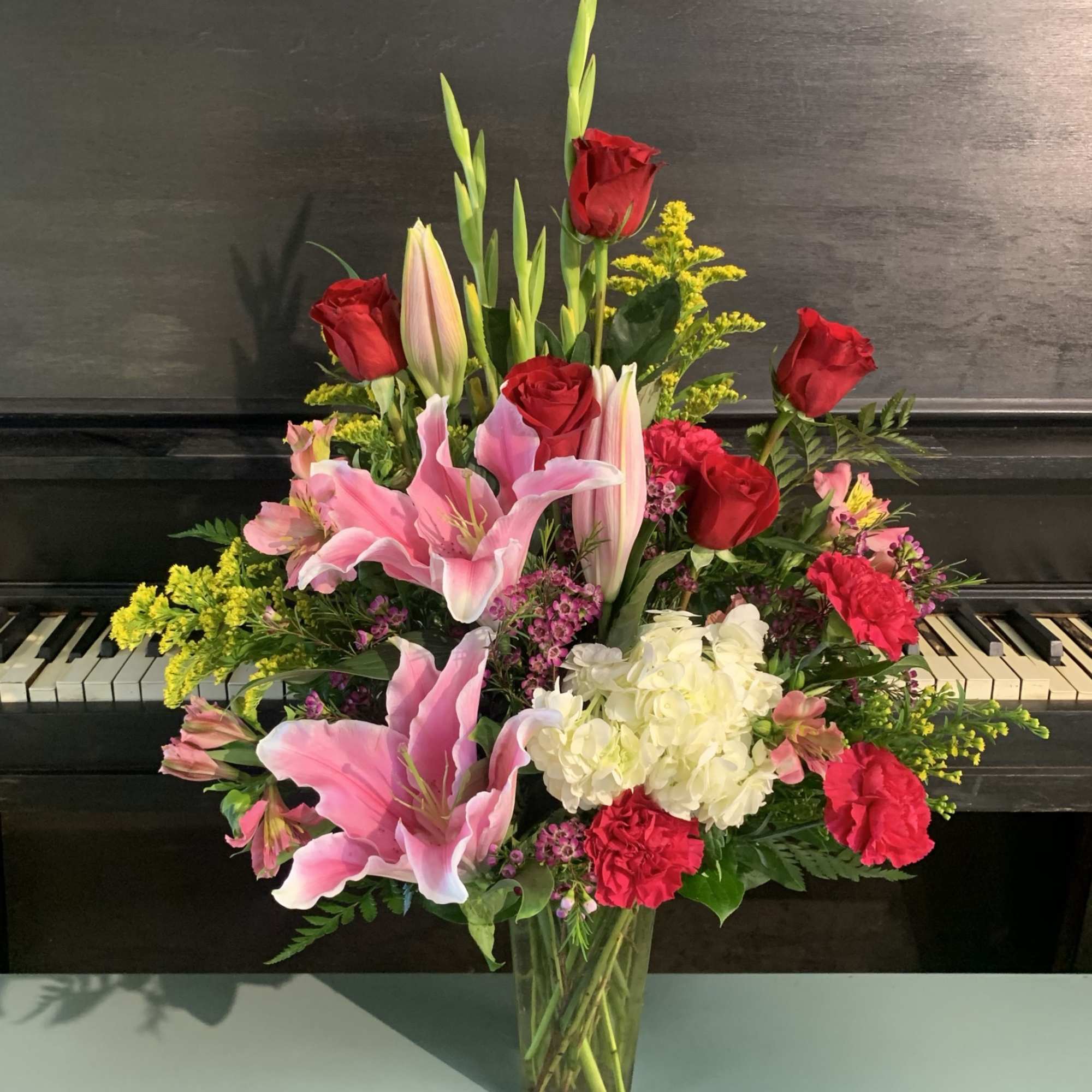 Pink lilies and red roses in a clear glass vase
