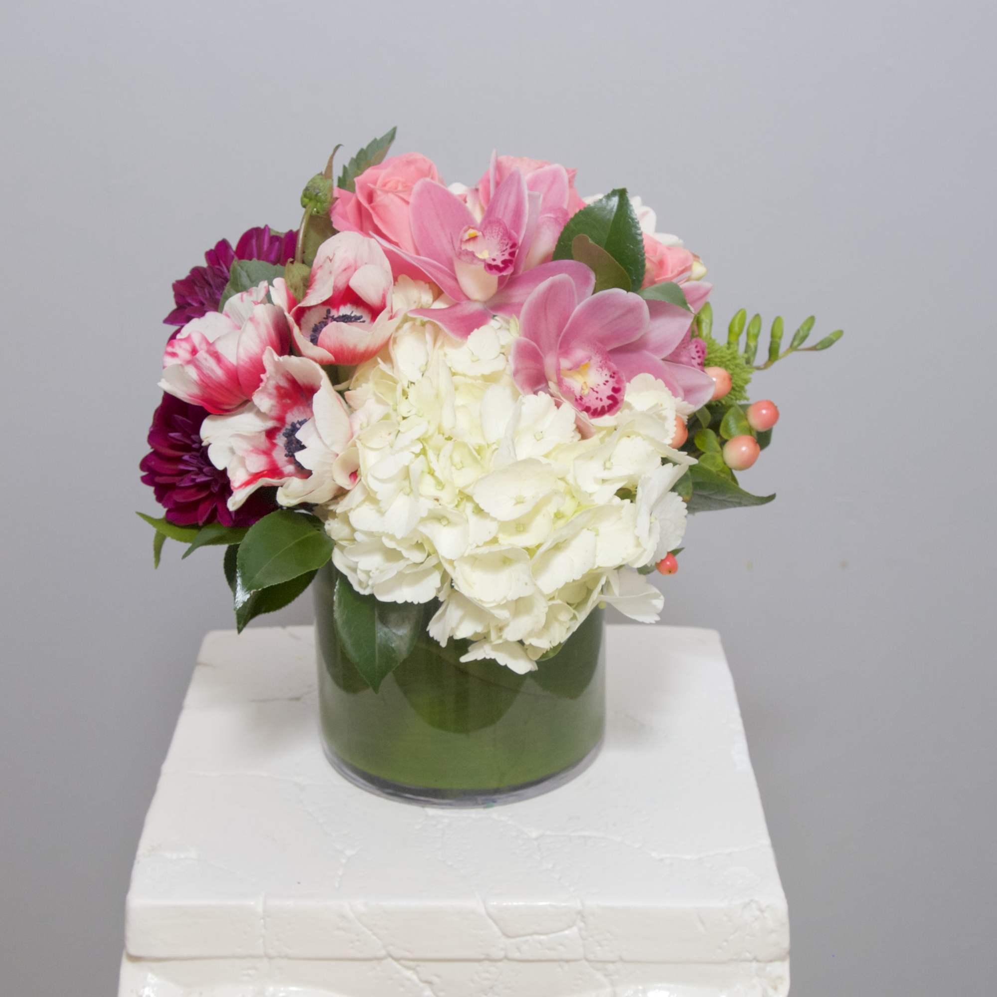 Pink and white mixed flower arrangement in a glass vase