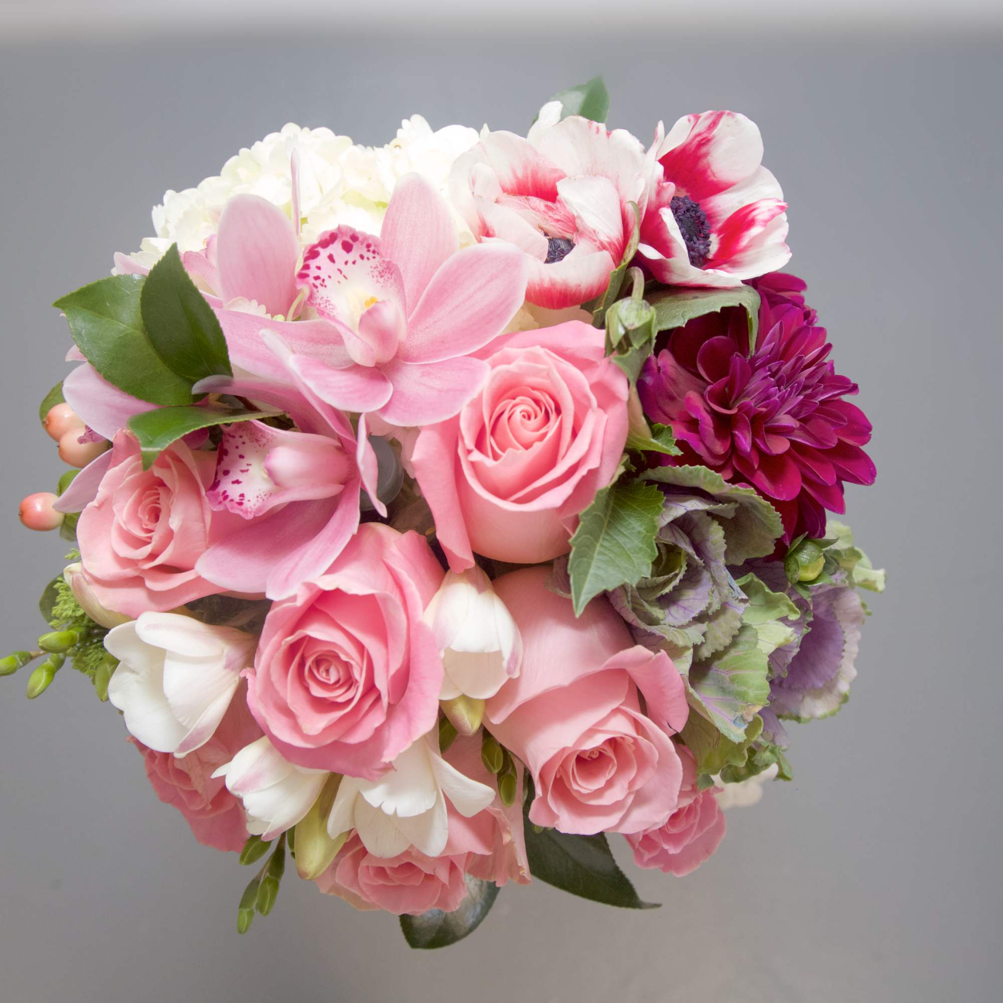 Pink bouquet with roses, orchids, and white blooms