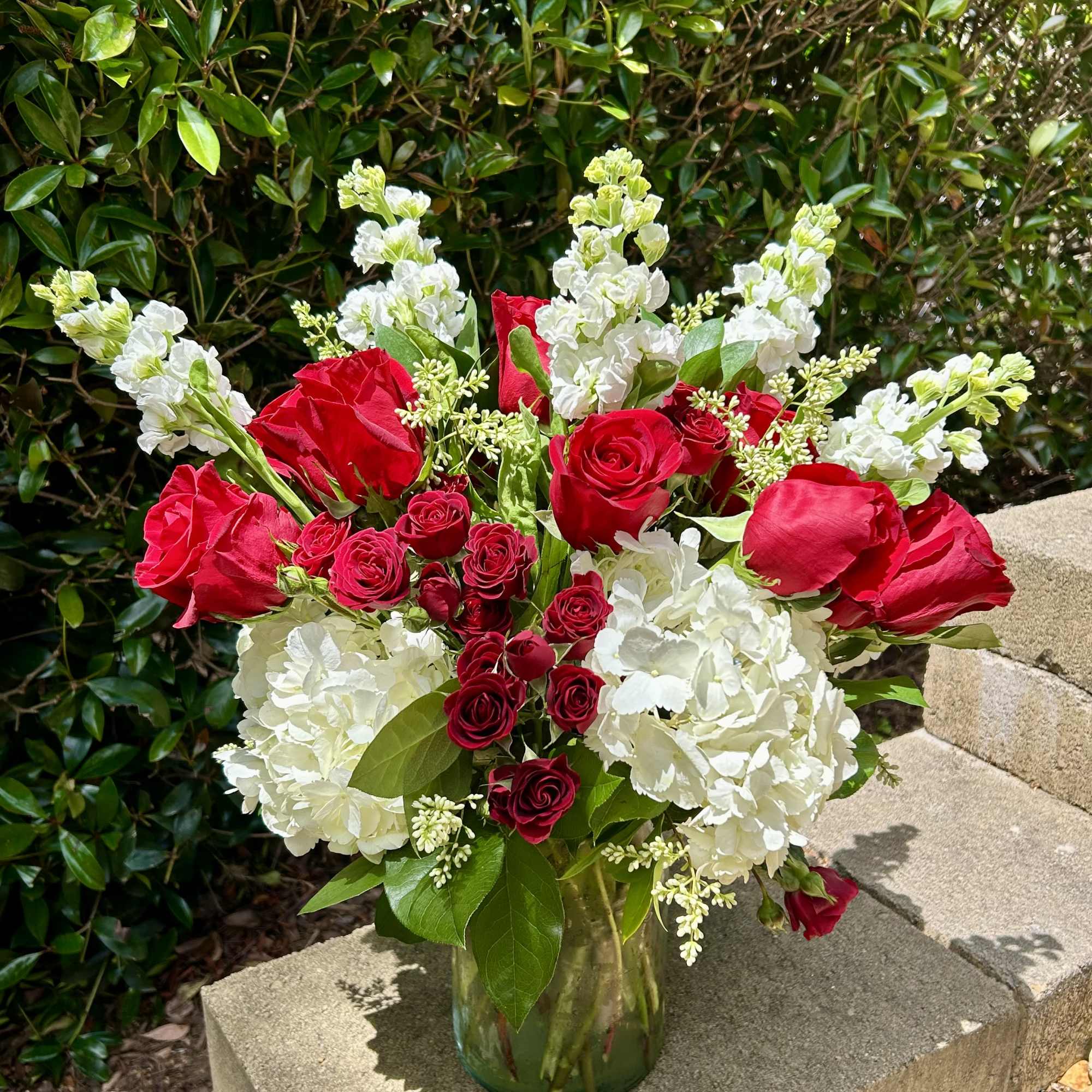 Red roses and white hydrangeas in a glass vase