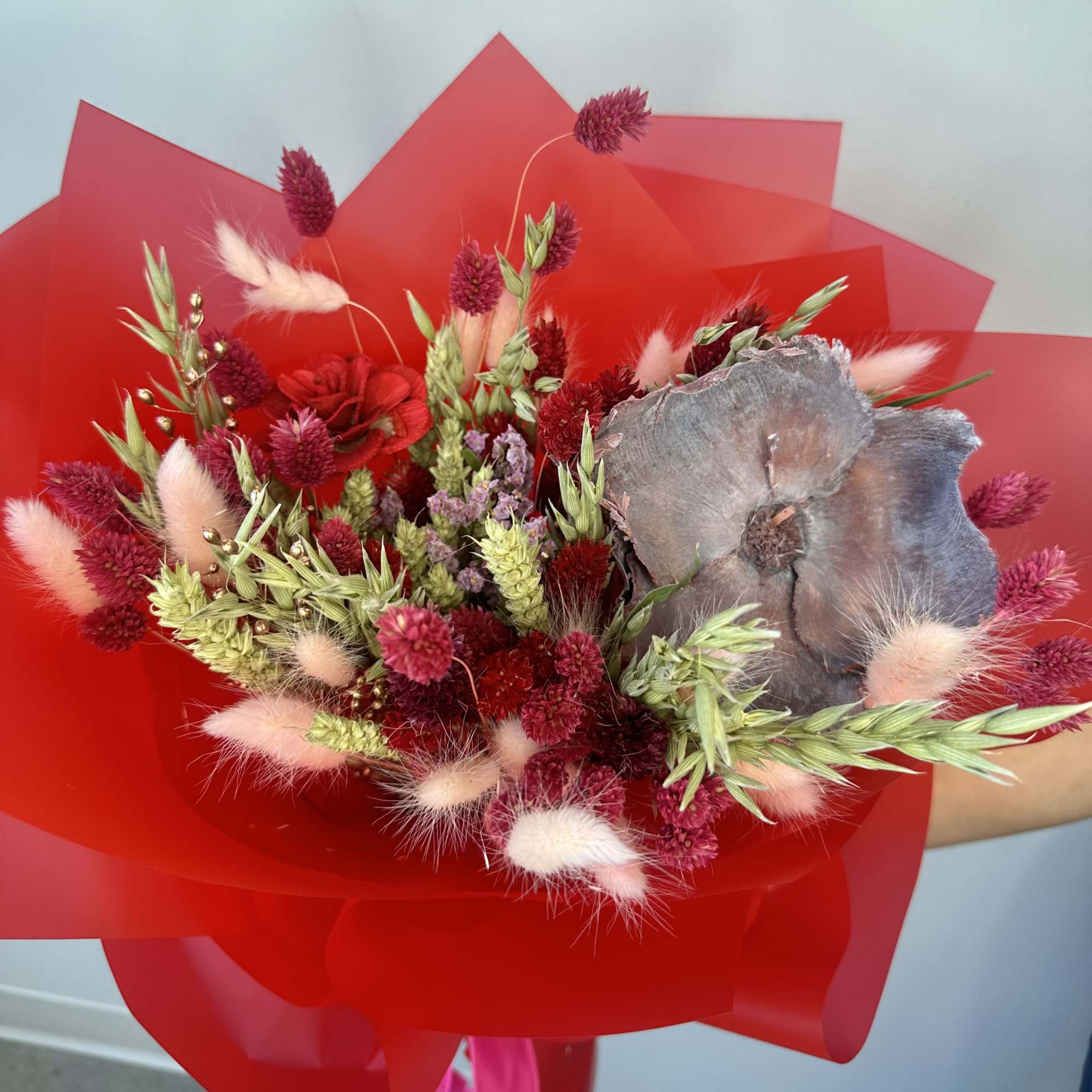 Bouquet of red and pink flowers wrapped in bright red paper