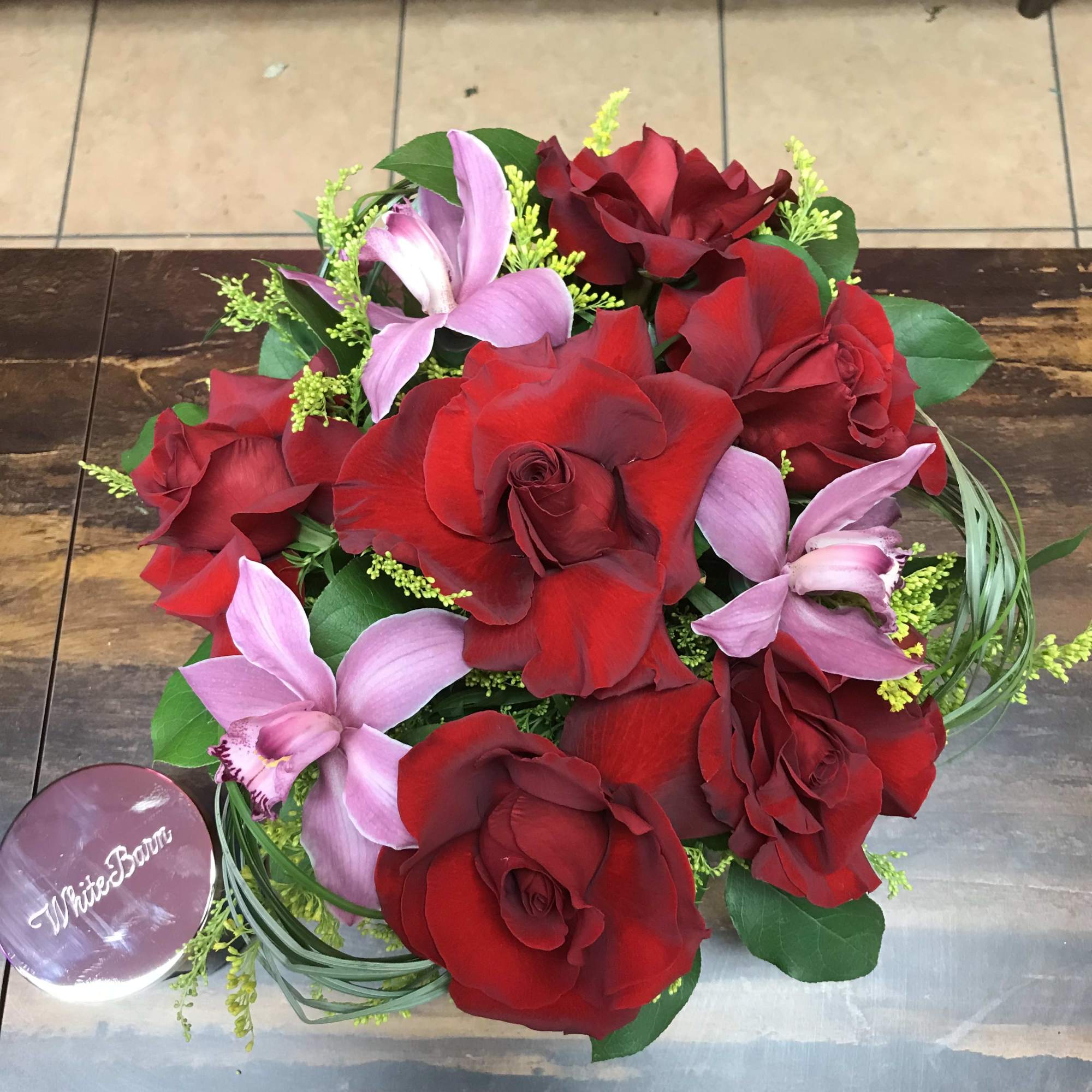 Red roses and orchids in a velvet hat box