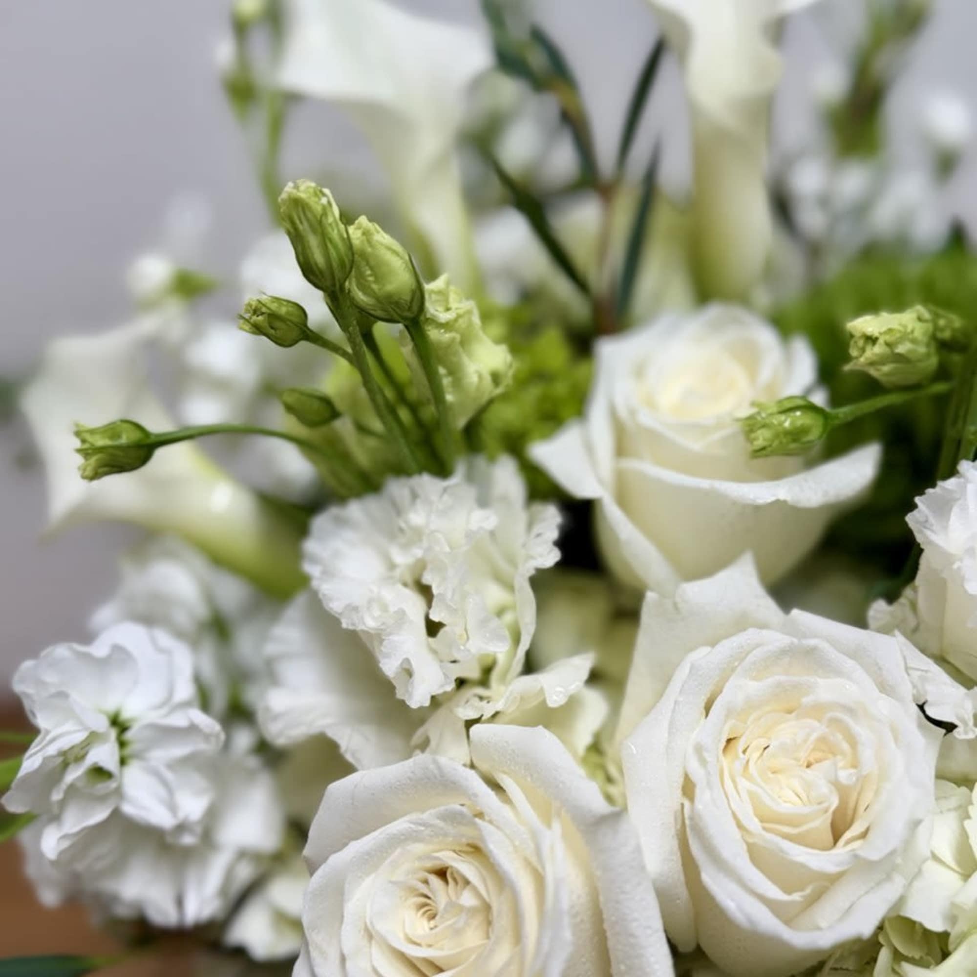 White roses and calla lilies in a soft floral arrangement