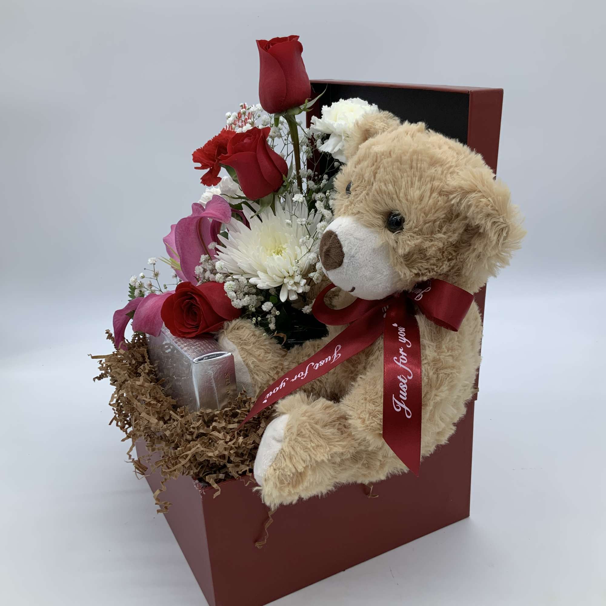 Gift box with red roses, white flowers, and a teddy bear