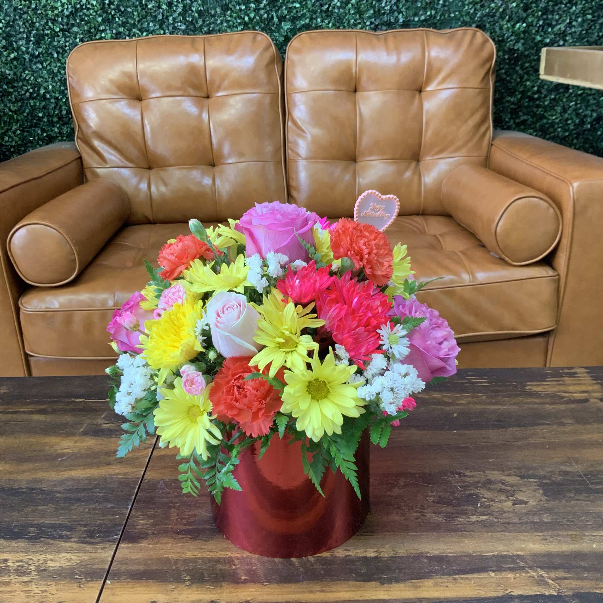 Dazzling metallic cylinder container with lilies, hydrangeas, roses, and other beautiful flowers.