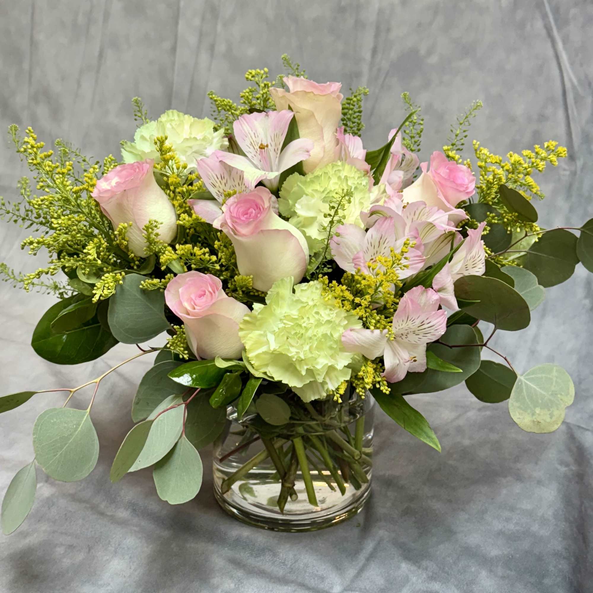 Pink roses and pale green carnations in a glass vase