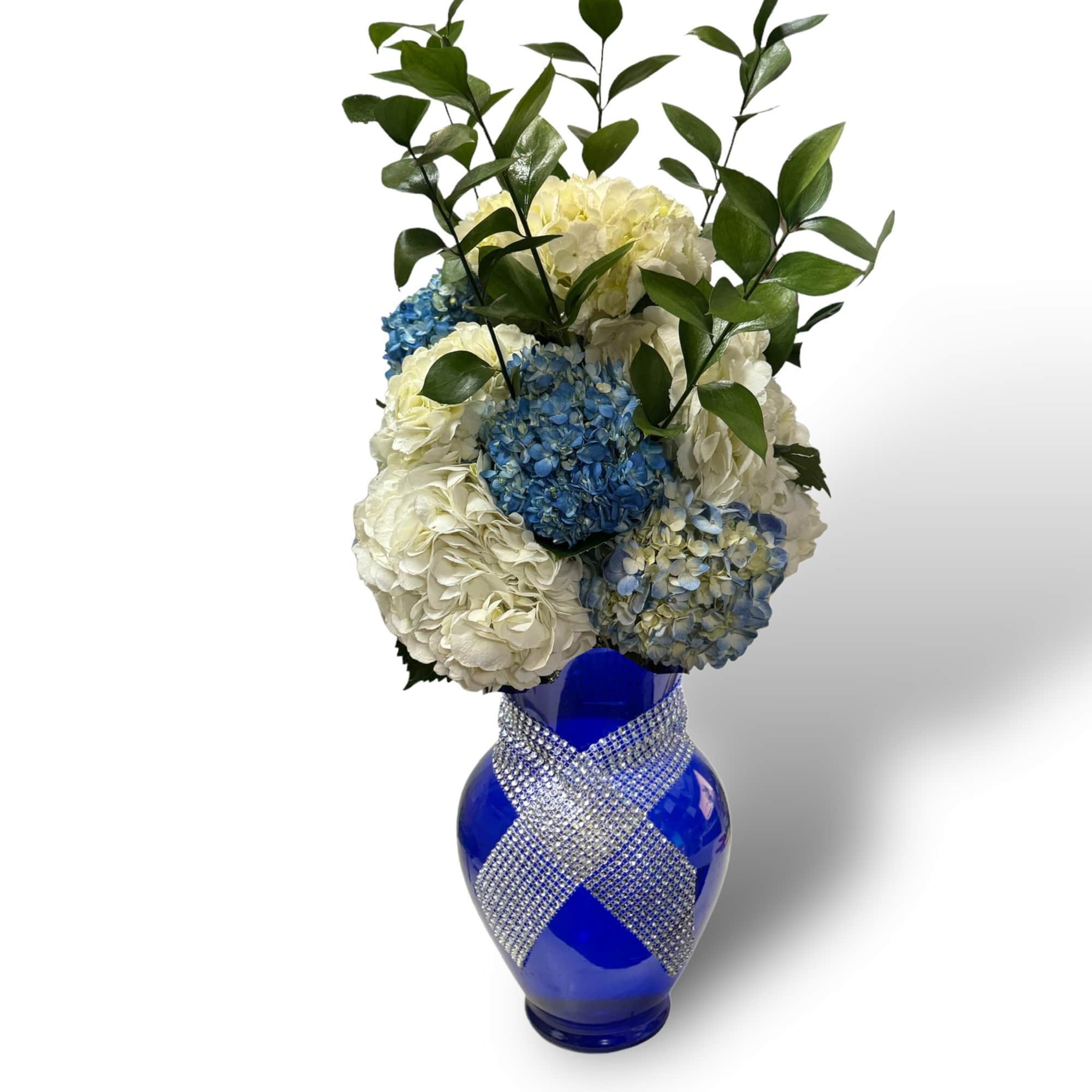 Blue and white hydrangea arrangement in a cobalt vase with rhinestone ribbon