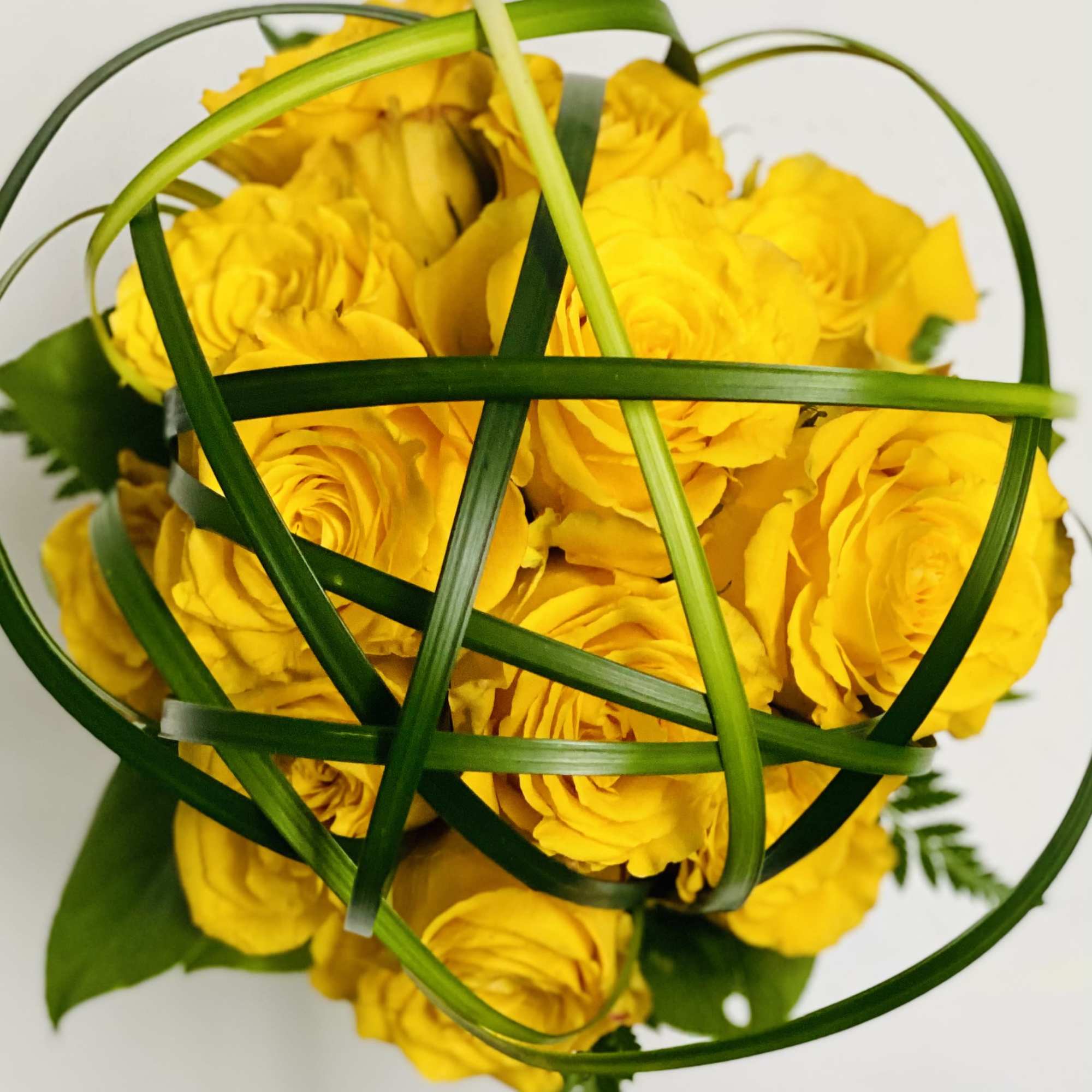 12 yellow roses encased in Lilly Grass with a Diamond wrapped vase