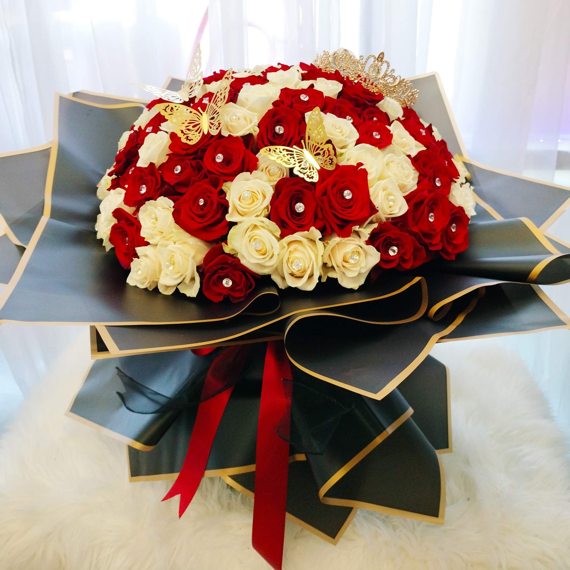 Bouquet of red and white roses with gold butterfly accents