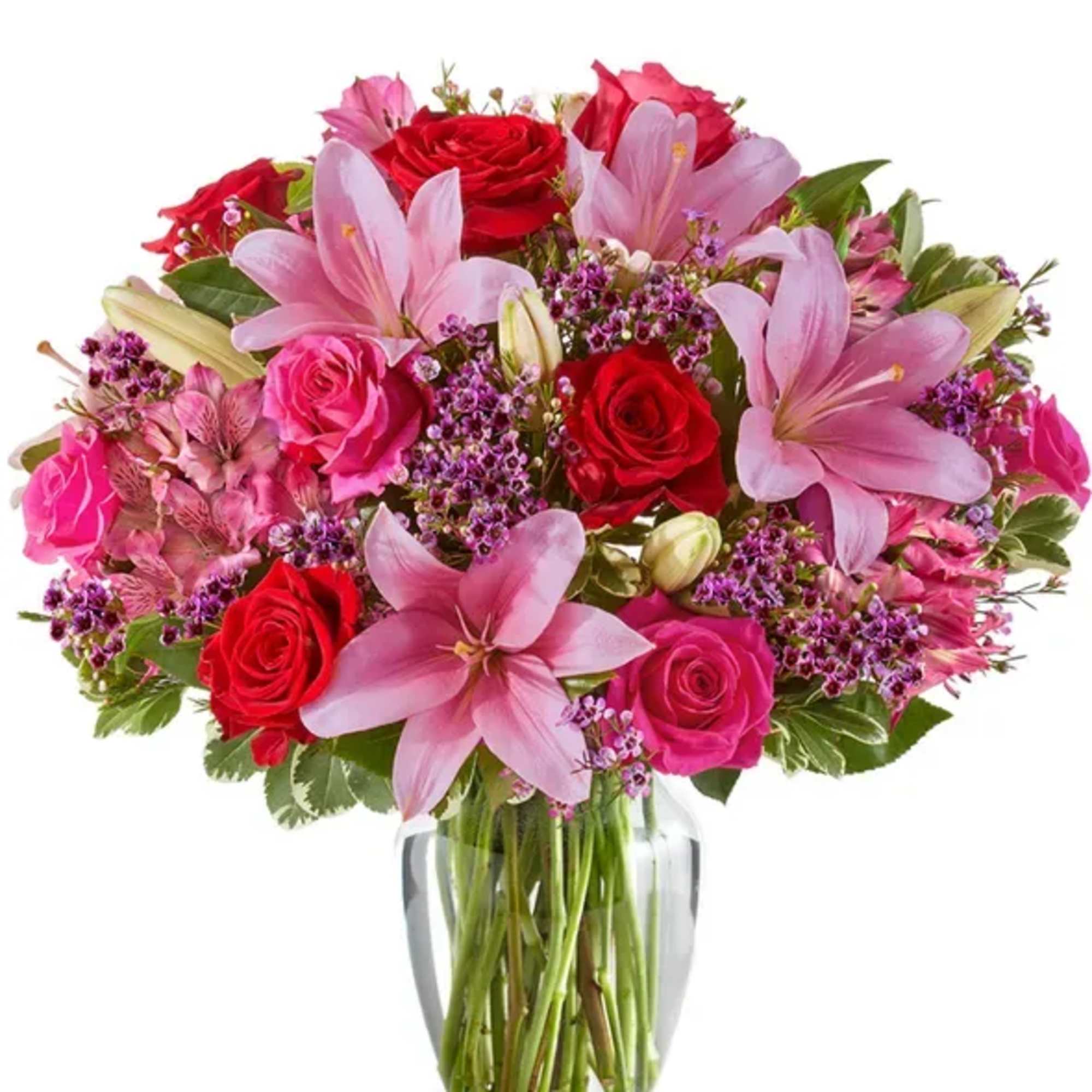 Bouquet of pink lilies and red roses in a clear glass vase