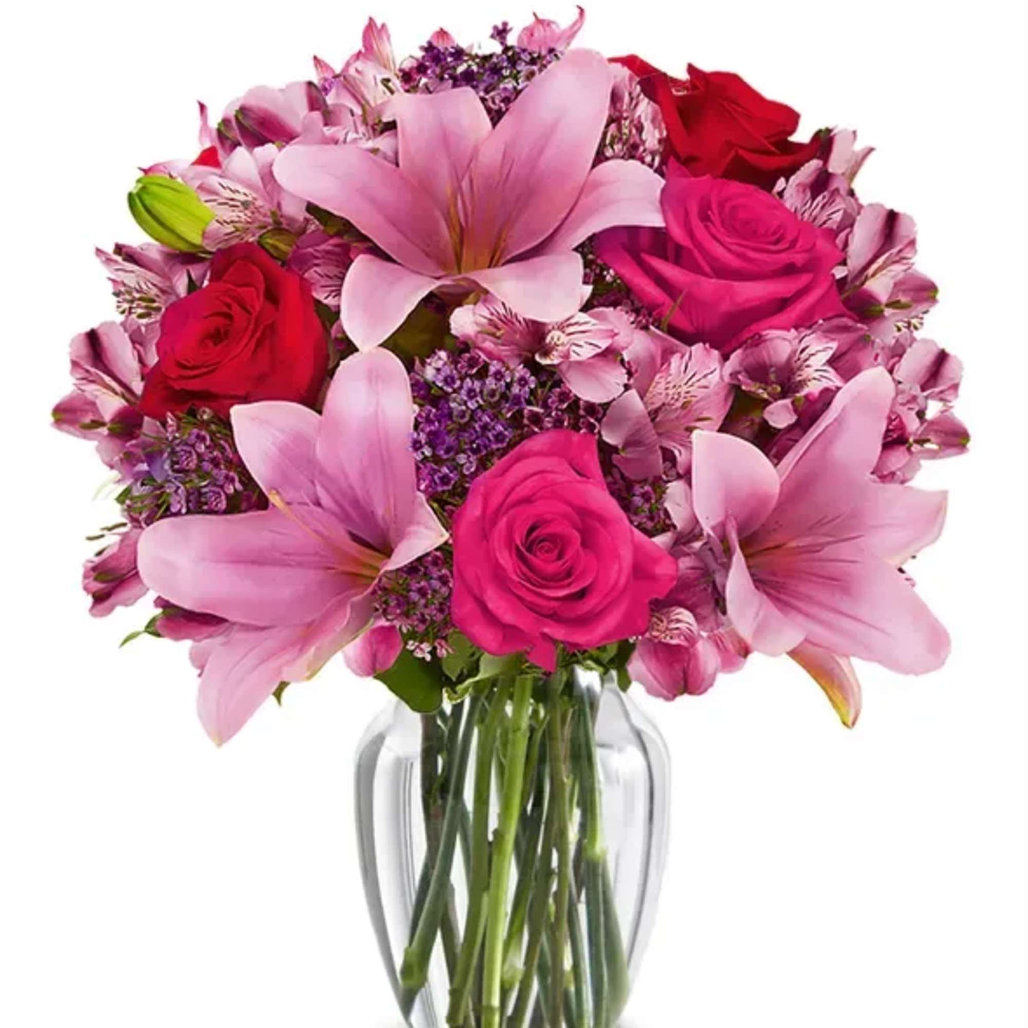 Pink lilies and roses arranged in a clear glass vase