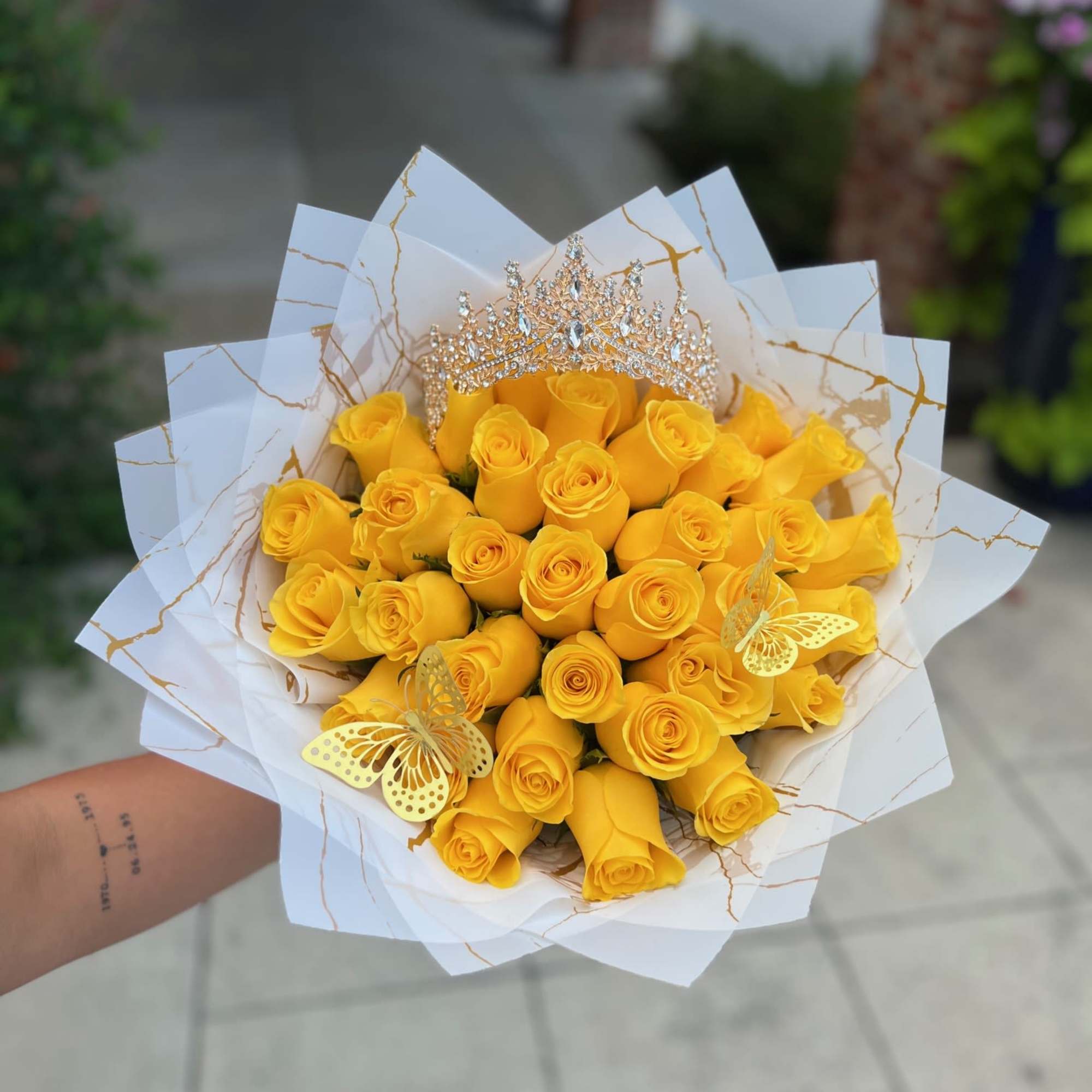 Bouquet of yellow roses with a jeweled tiara and butterfly decorations