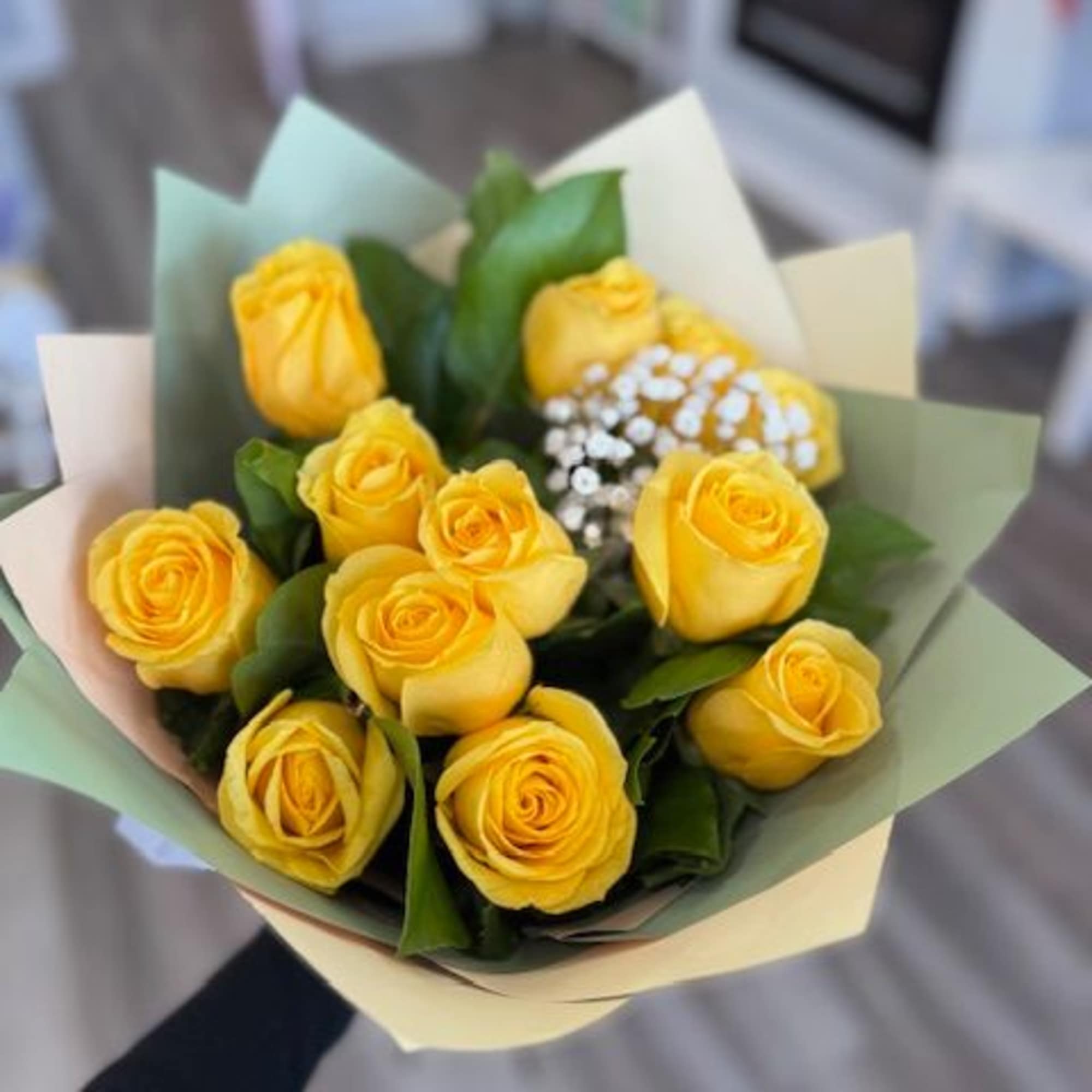 Bouquet of yellow roses wrapped in pastel paper