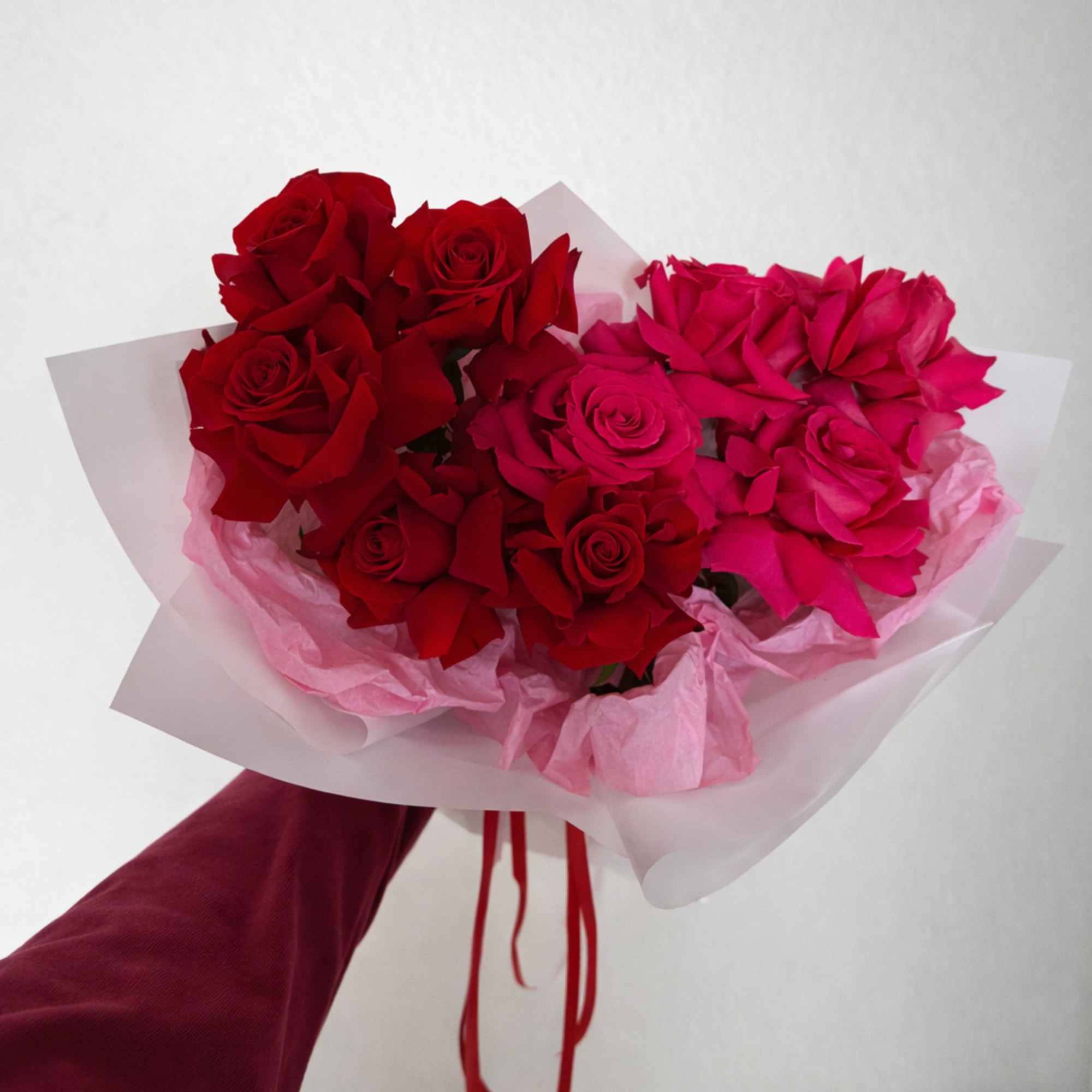 A fresh bouquet of red and pink roses, beautifully wrapped and ready