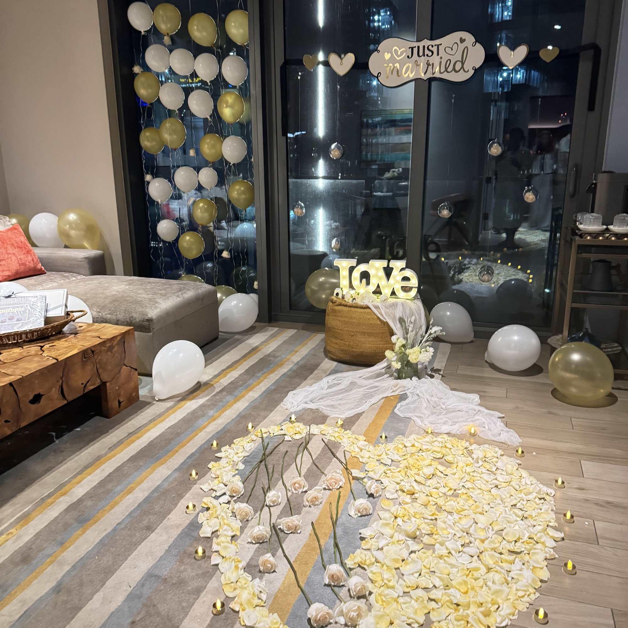 Wedding floor display with white and gold balloons and flower petals