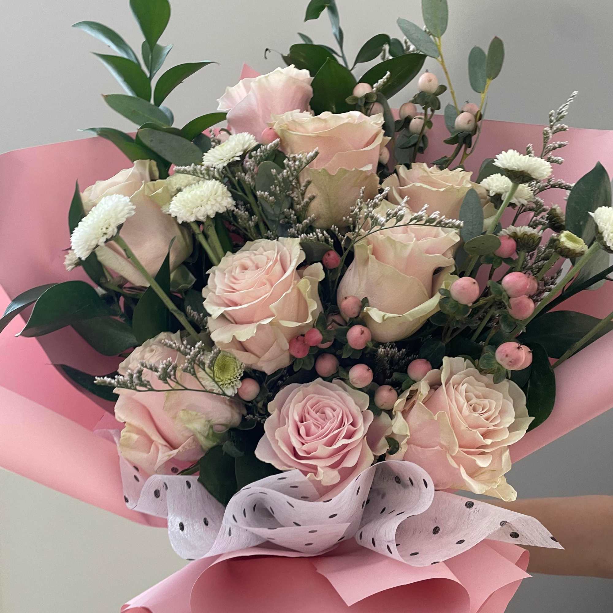 Pink rose bouquet with white filler flowers and pink wrapping