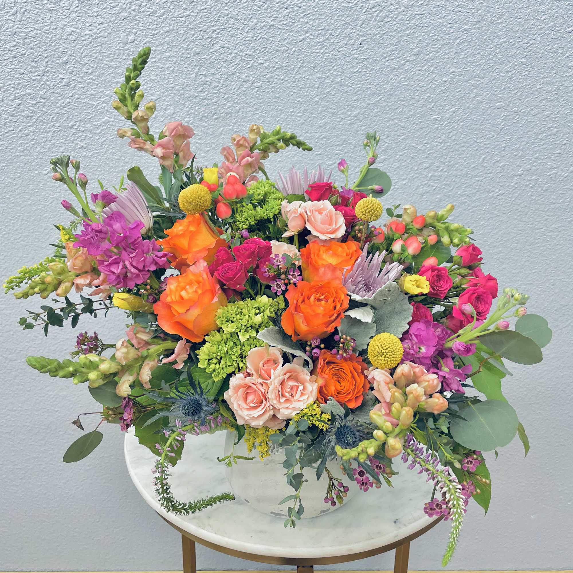 Colorful mixed bouquet in a white vase on a small table