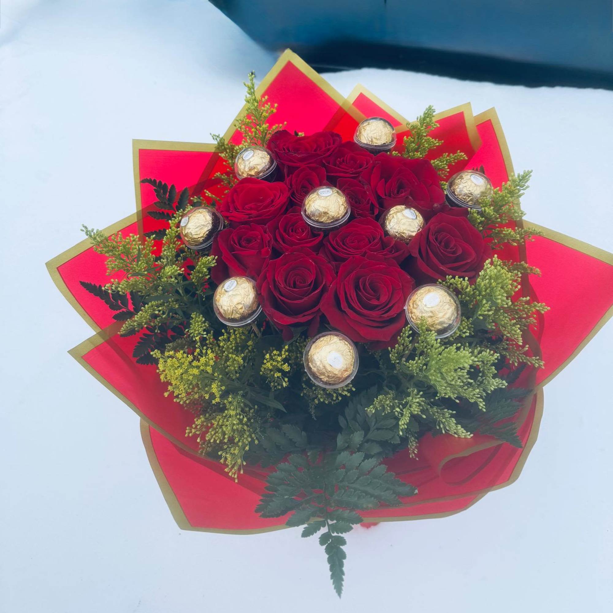 Red rose bouquet with gold-wrapped chocolates and red paper wrap