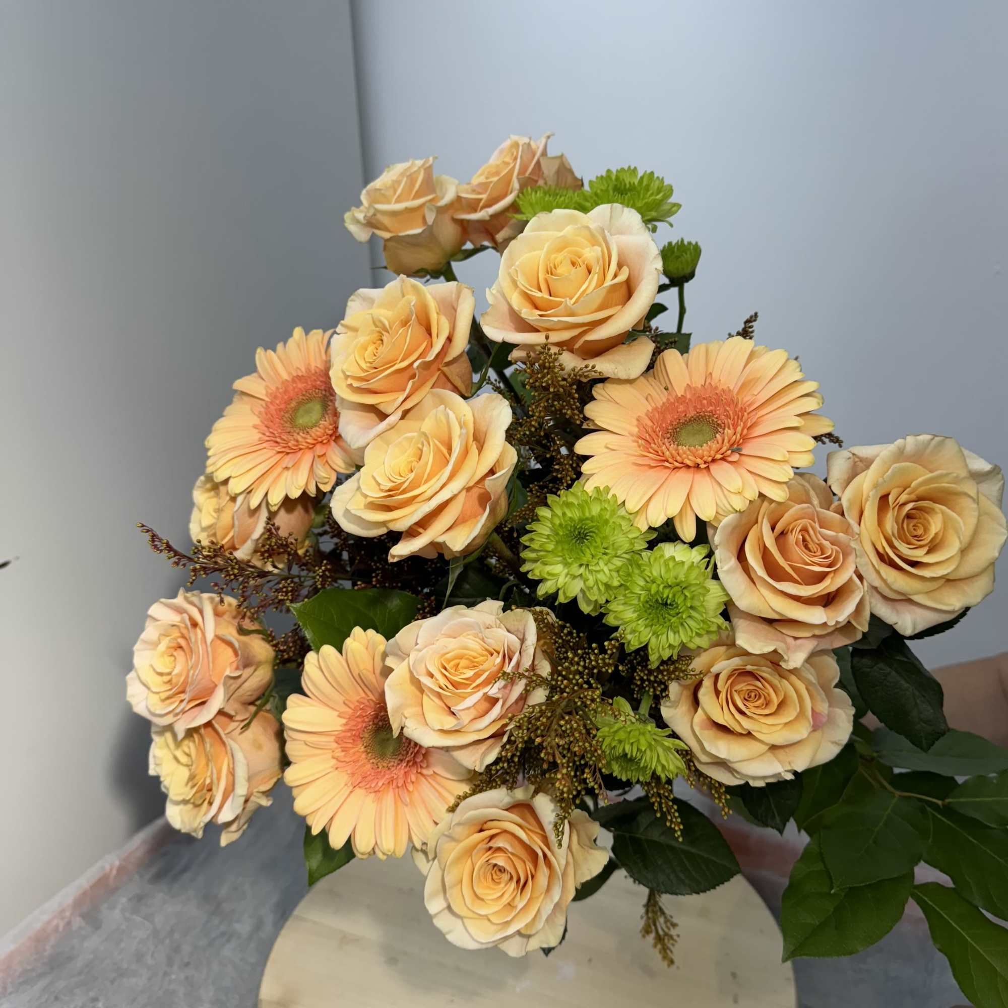 Bouquet of peach roses and peach gerbera daisies