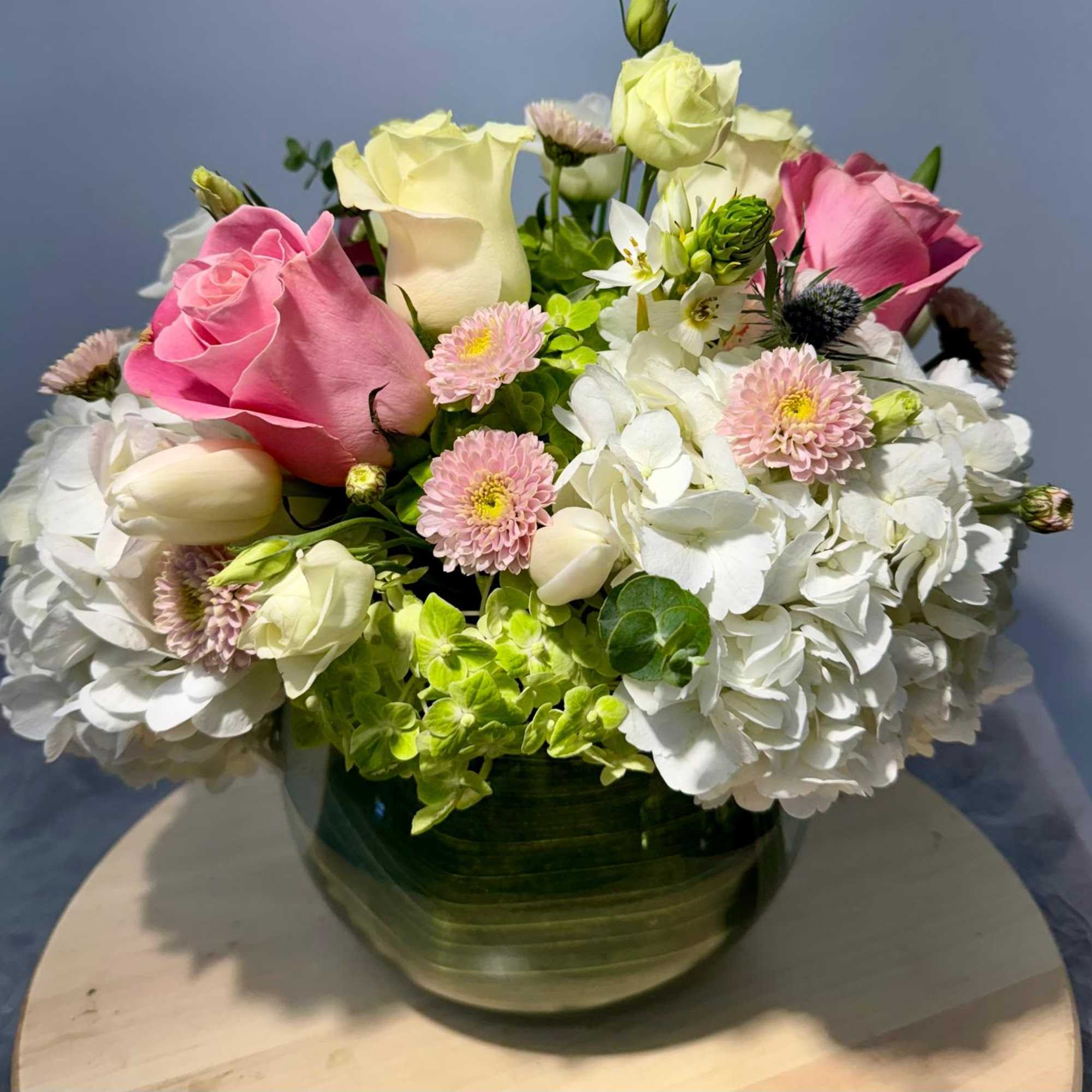 Pink and white roses with hydrangeas in a glass vase