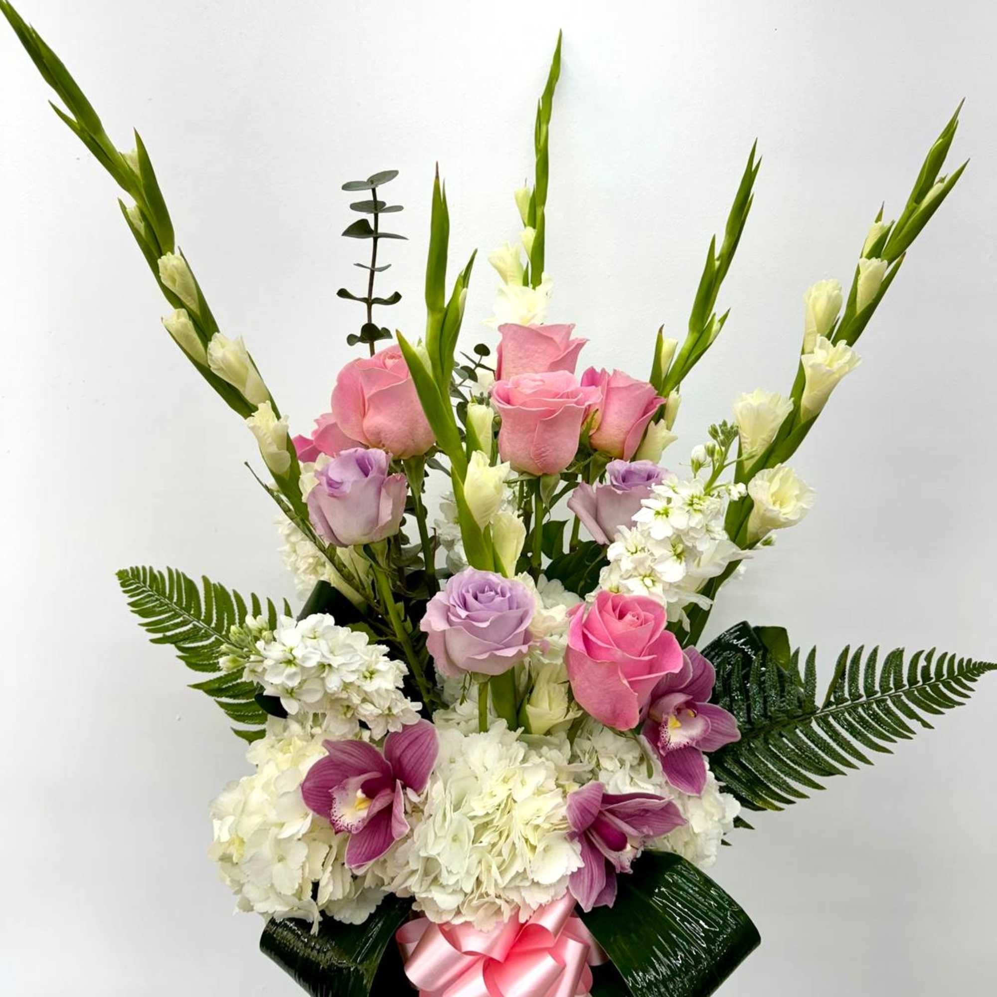 Pink and lavender roses with white flowers in a glass vase