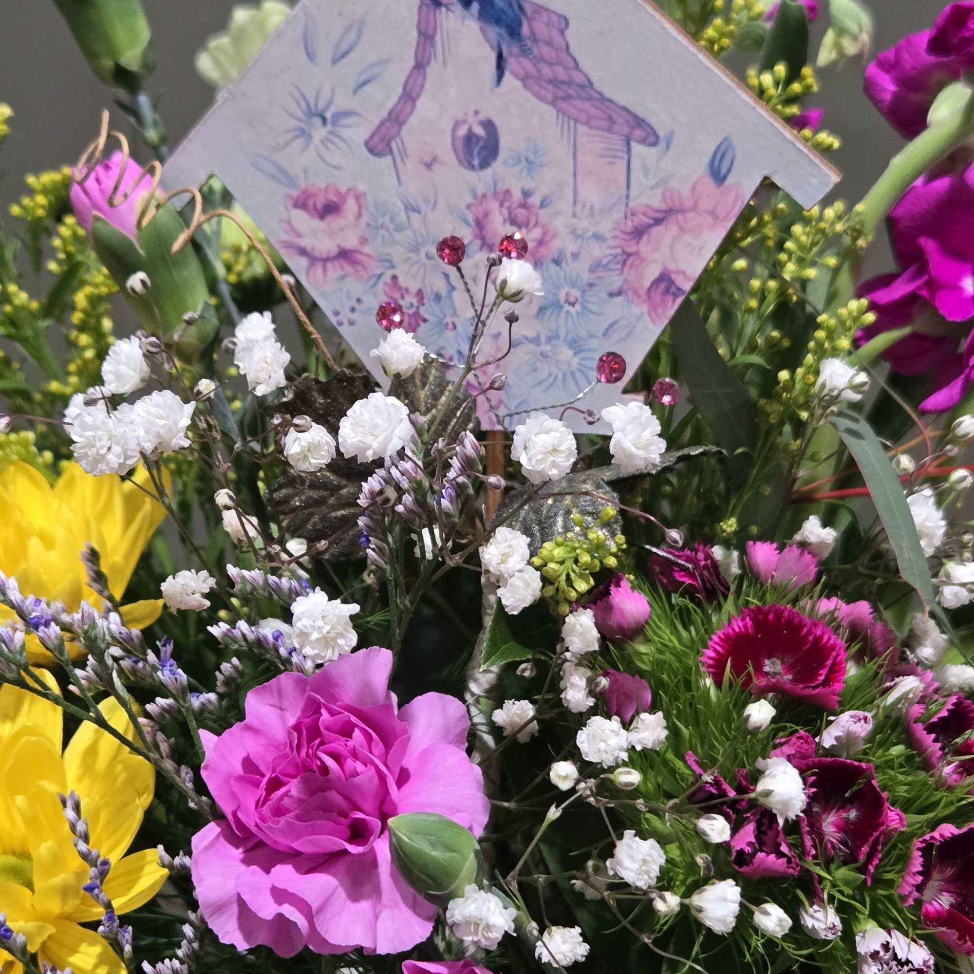 Sunshine-bright yellow chrysanthemums and hot pink carnations give this mixed flower arrangement