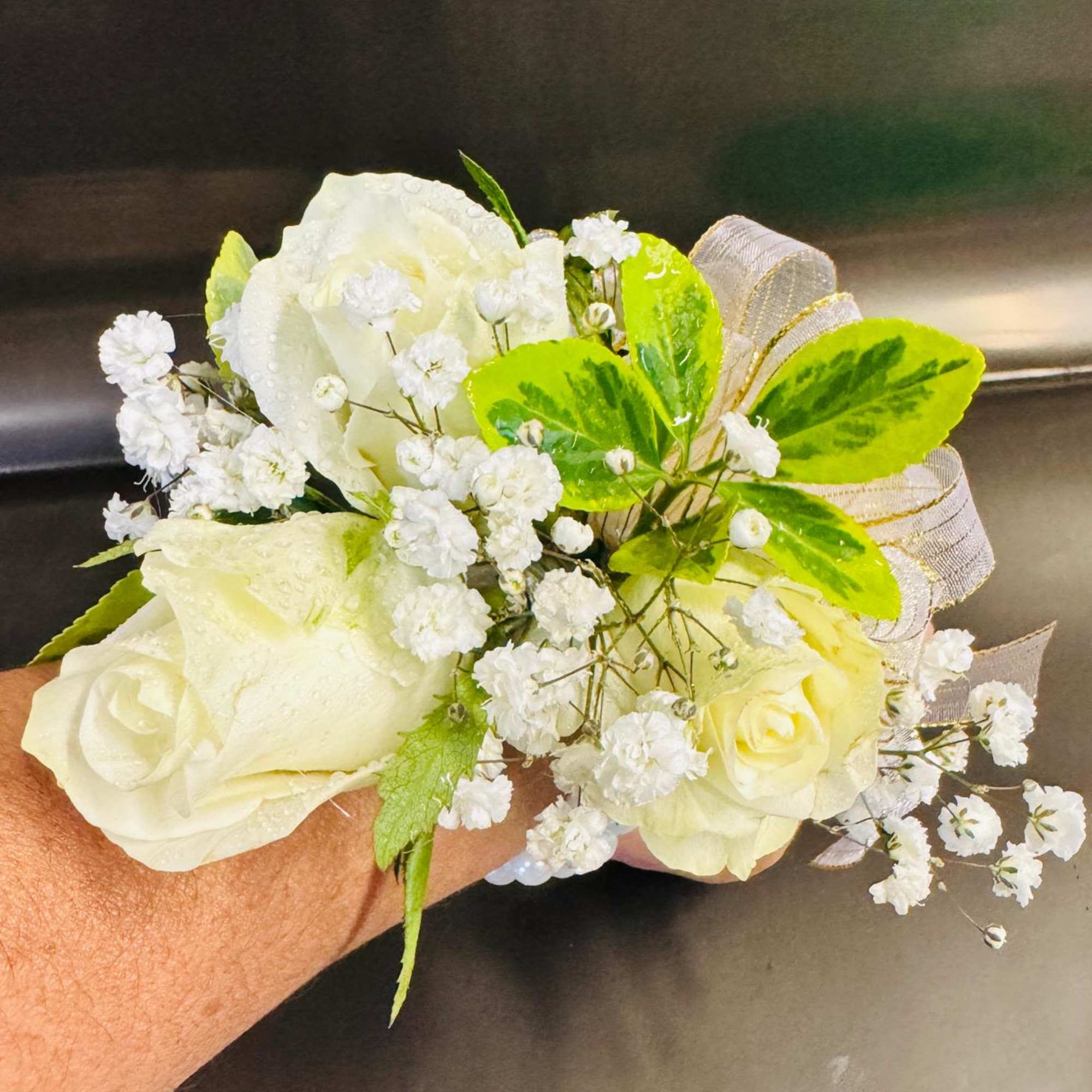 White rose wrist corsage with baby's breath and green ribbon