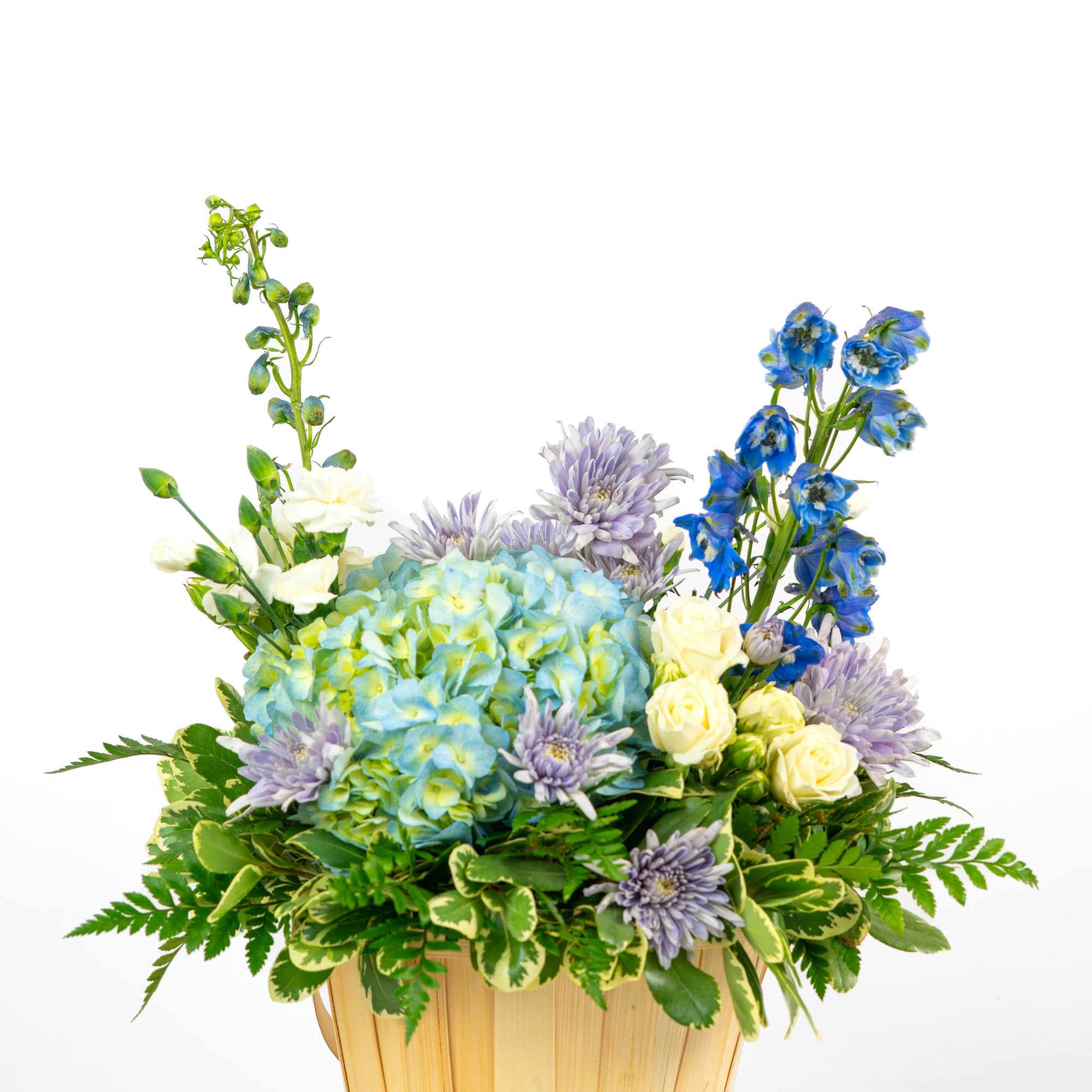 Basket arrangement with blue hydrangeas, white roses, lavender mums, and blue delphinium