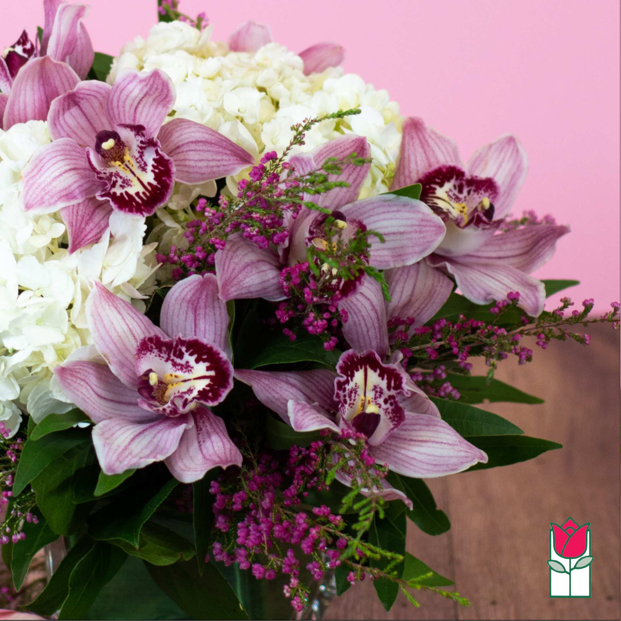 Pink orchids with white hydrangeas in a glass vase