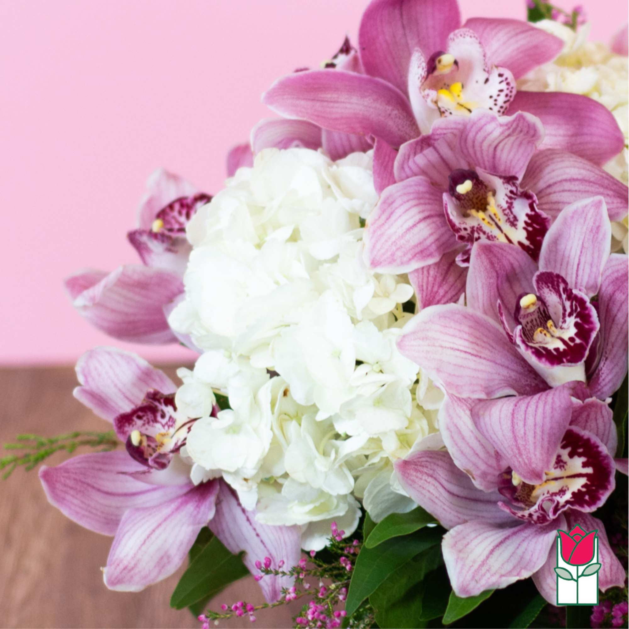 Pink orchids arranged around a white hydrangea cluster