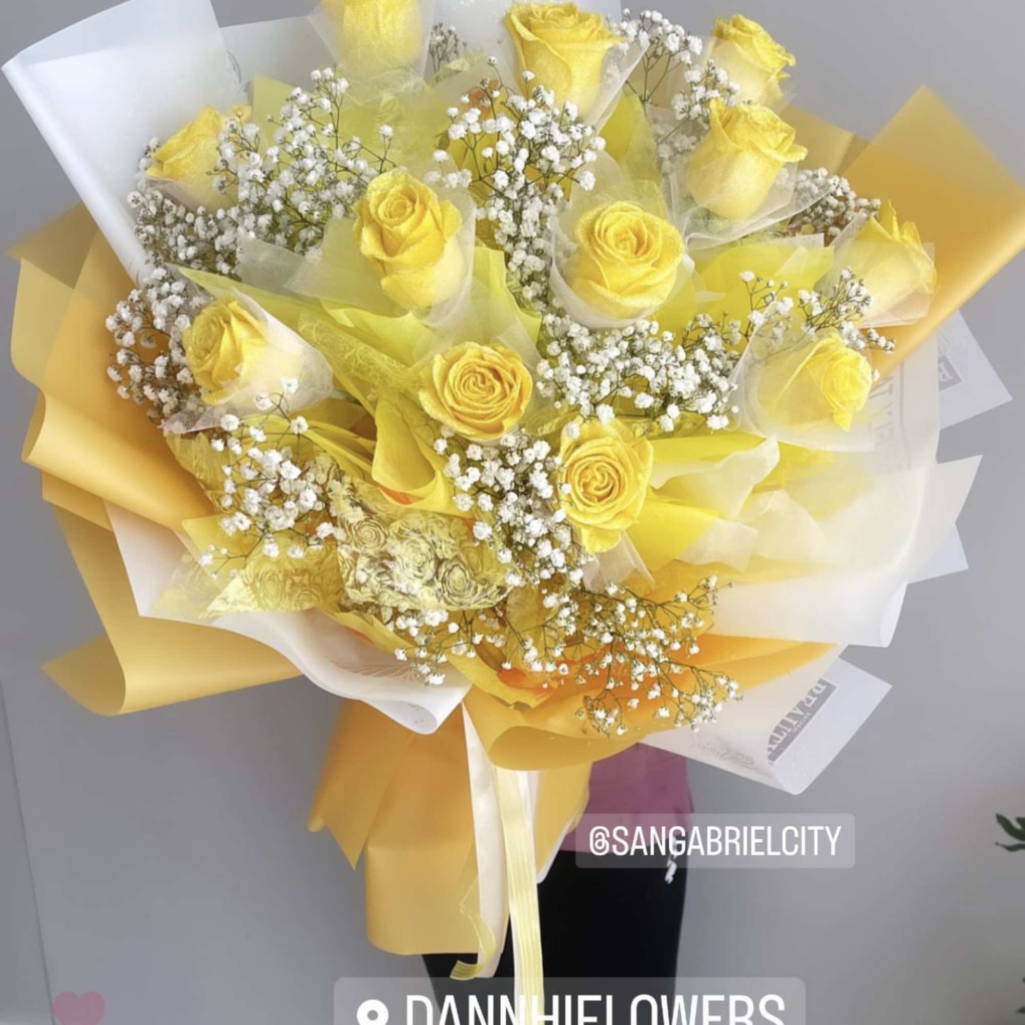 Bouquet of yellow roses with white baby's breath in yellow and white wrap