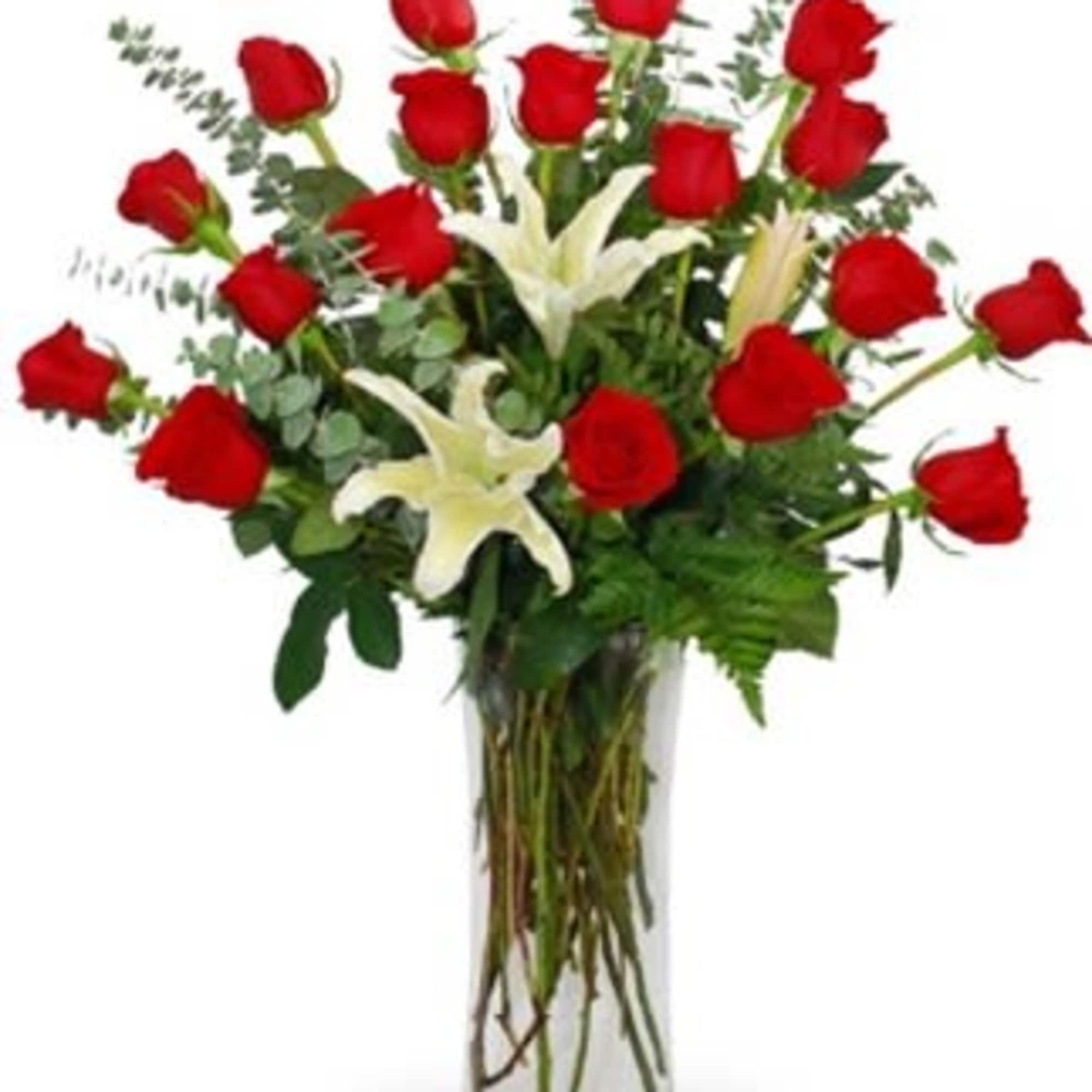 Red roses and white lilies arranged in a tall glass vase