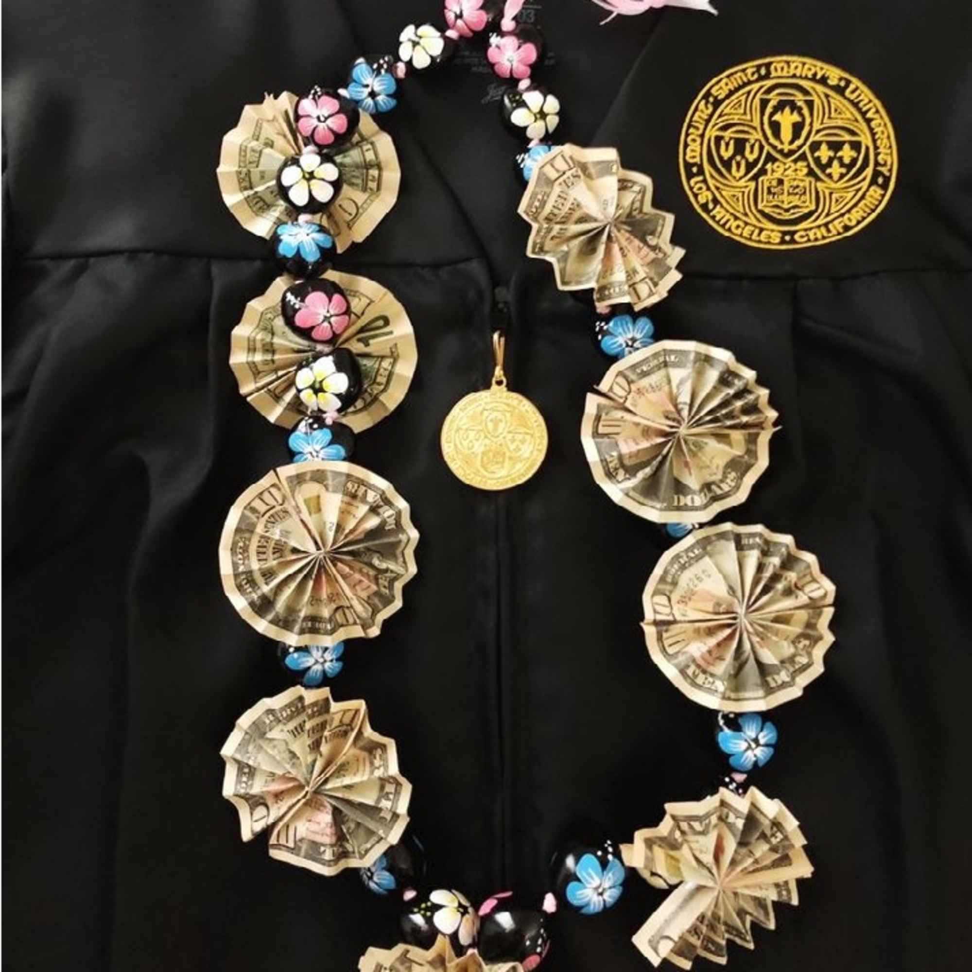 Money lei with flower beads on a black graduation gown