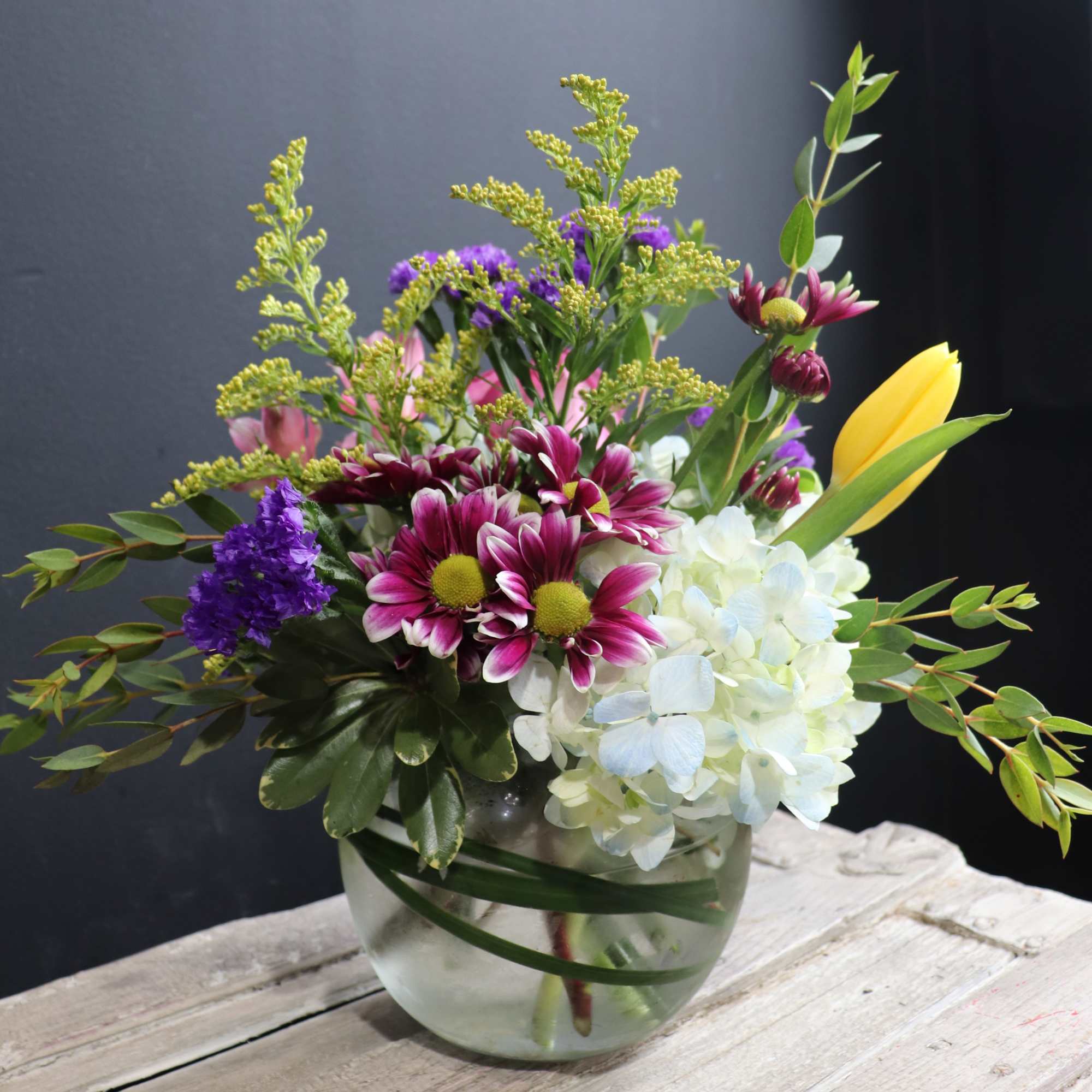 This a lively colorful arrangement with a variety of spring flowers like
