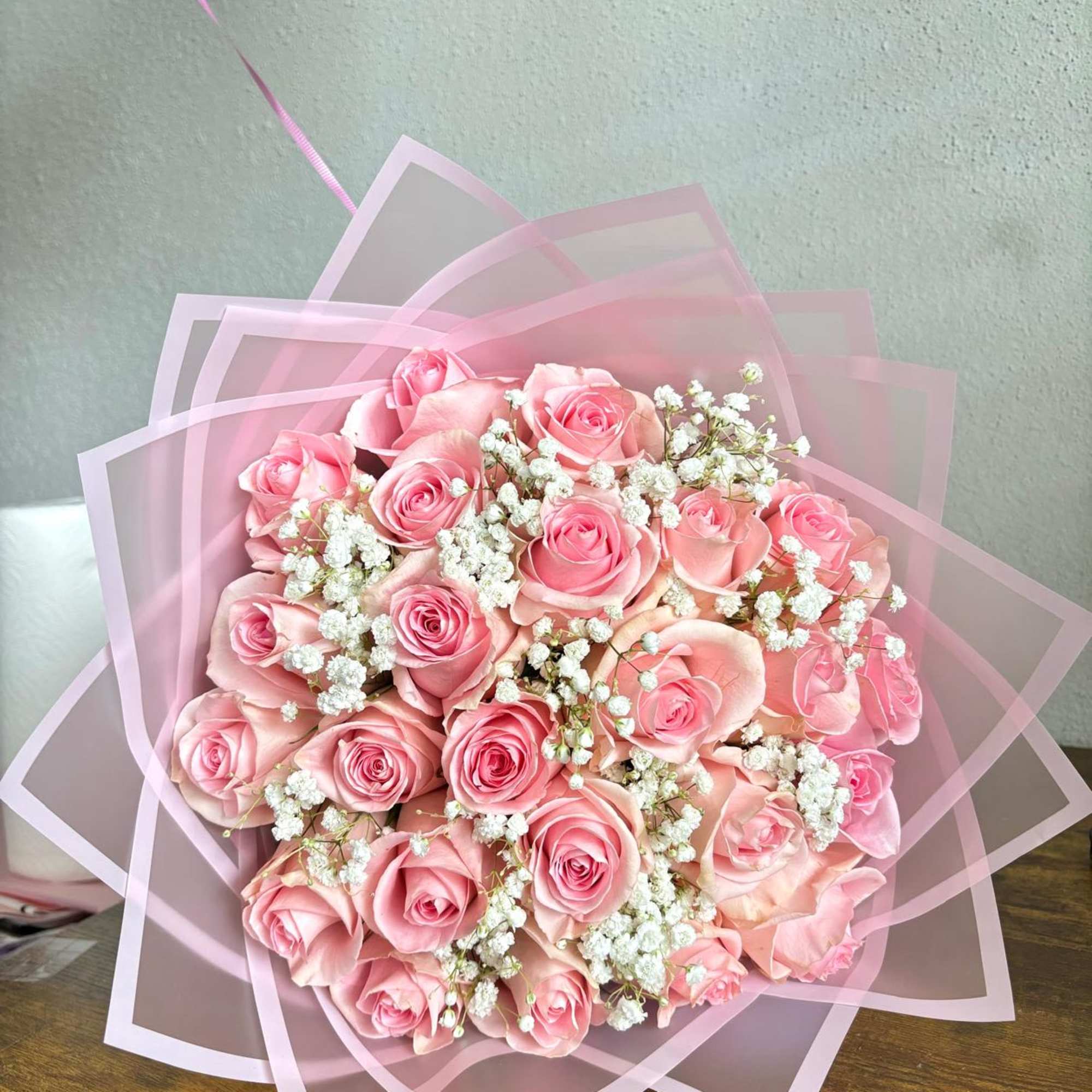 Pink rose bouquet wrapped in translucent pink paper