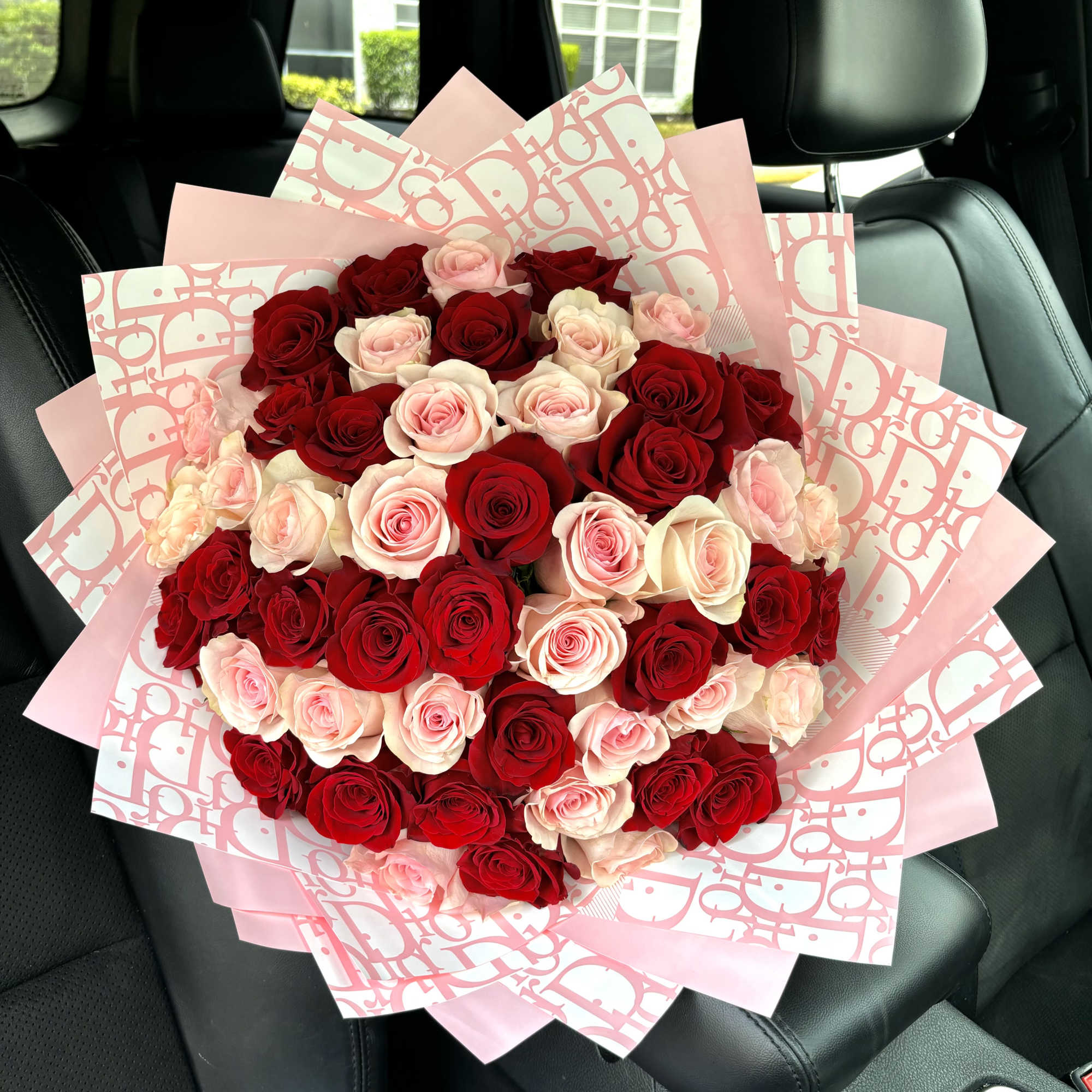 Large bouquet of red and blush roses wrapped in pink paper