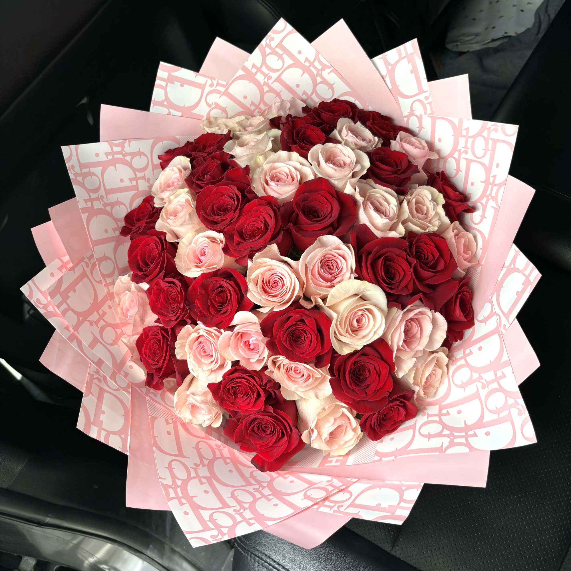 Bouquet of red and blush roses wrapped in pink paper