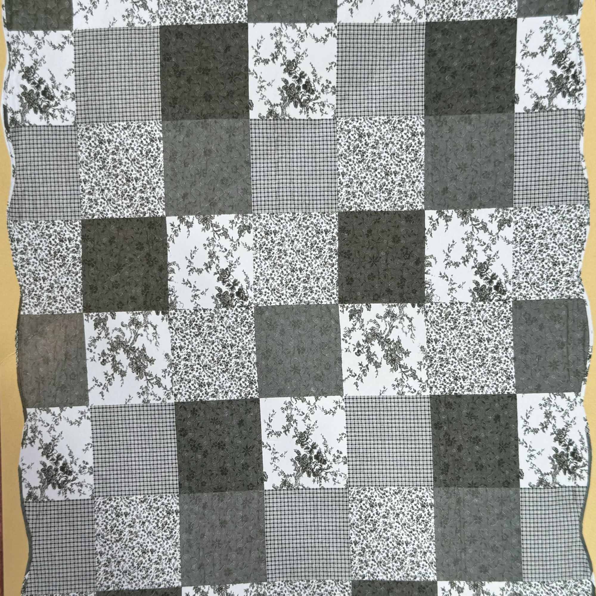 Black-and-white patchwork quilt with floral and checkered squares