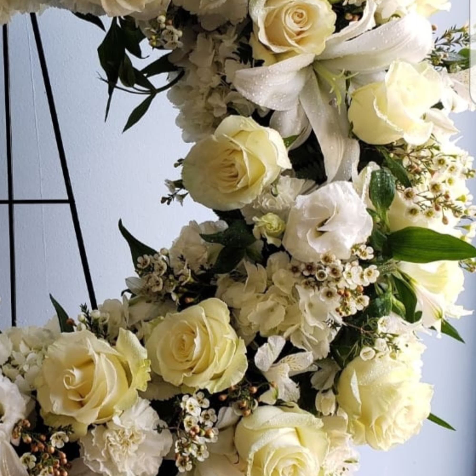Cream roses and white flowers arranged in a large floral display