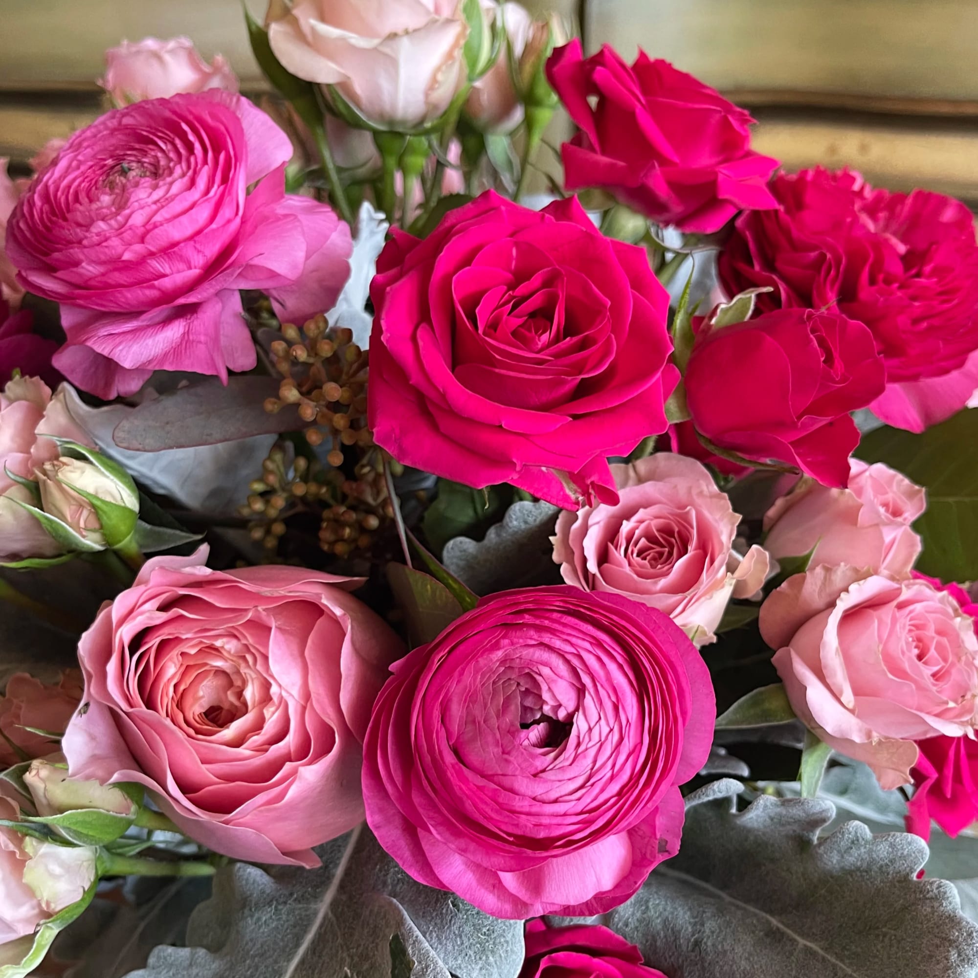 Bouquet of pink roses and ranunculus with silvery foliage