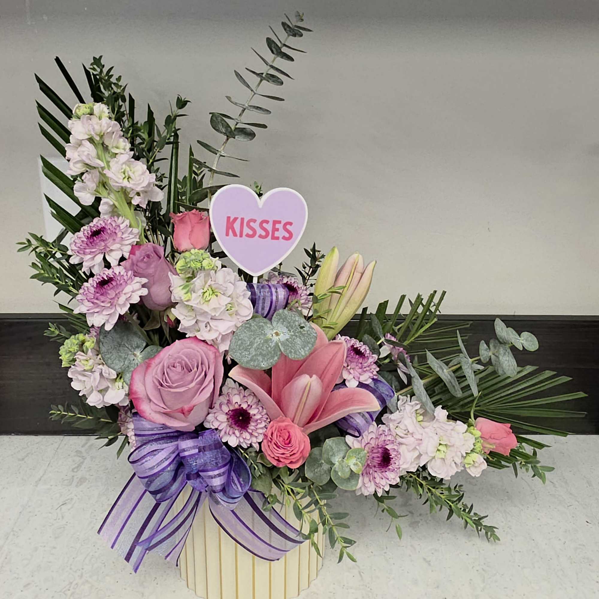 A playful heart pick and lush pastel blooms make this "L" for