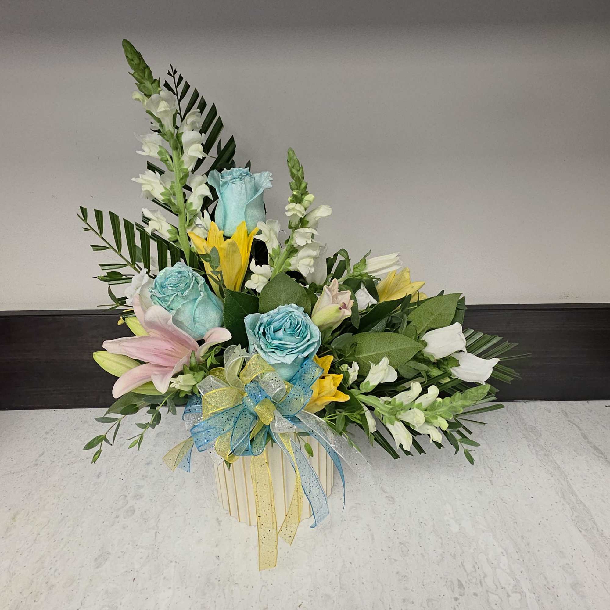 A playful heart pick and lush pastel blooms make this "L" for