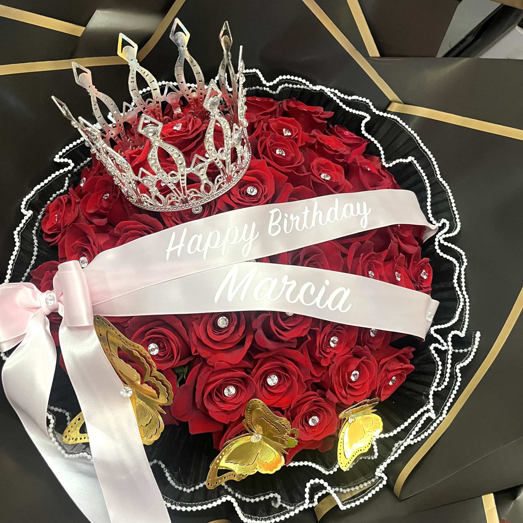 Red rose bouquet with a silver crown and birthday ribbon