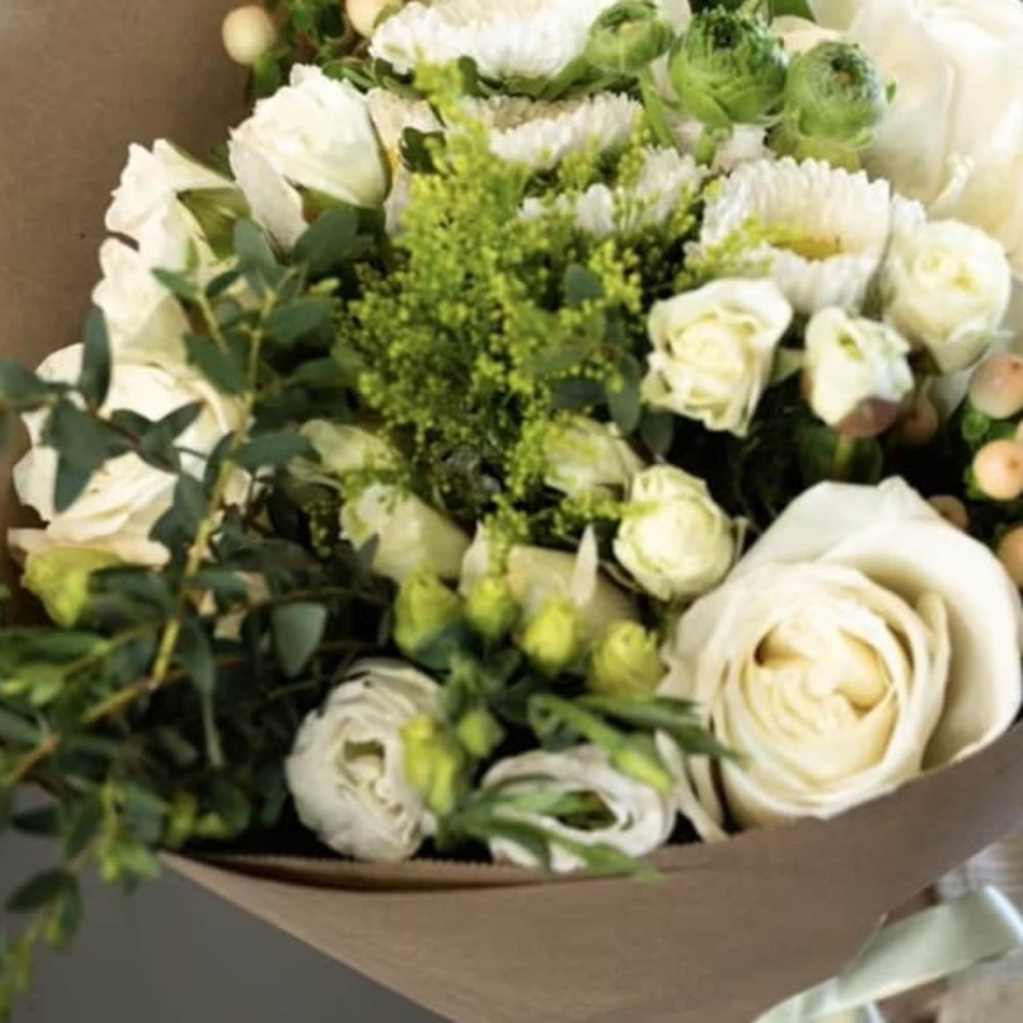 Experience the timeless beauty of our hand-tied white bouquet, lovingly wrapped in