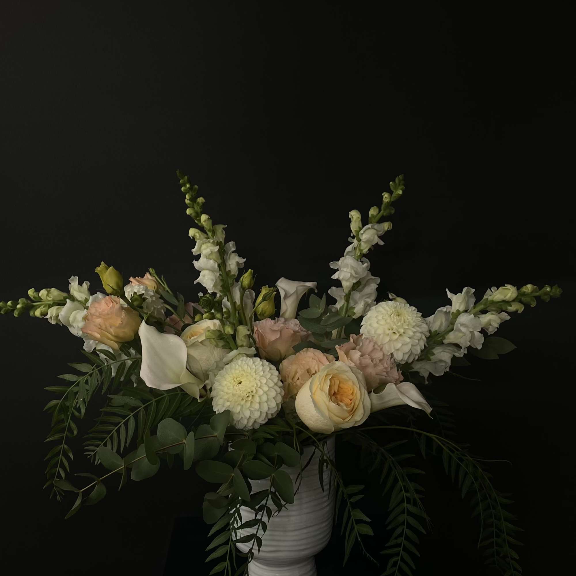 White vase arrangement with pale peach and white flowers