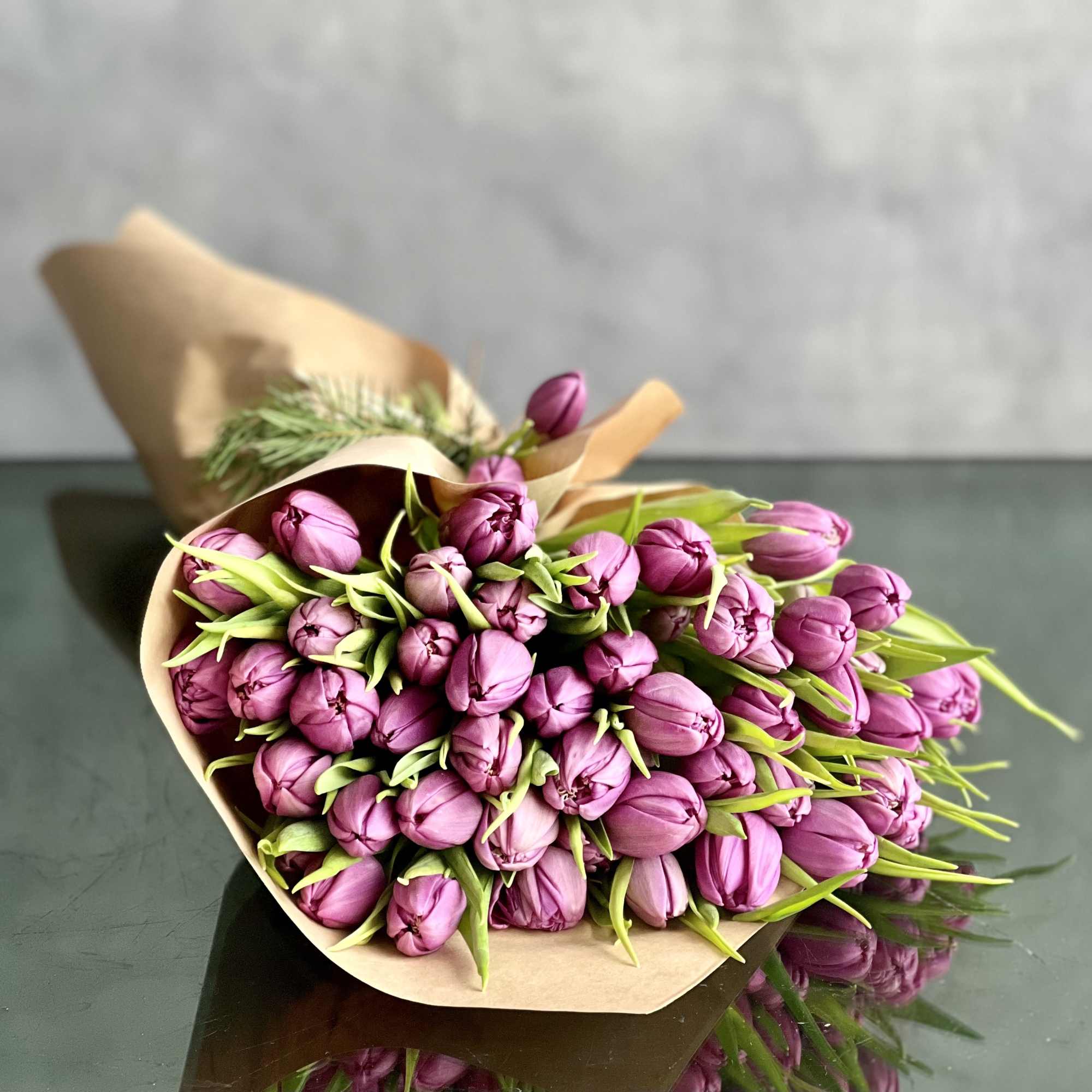 Bouquet of purple tulips wrapped in brown paper