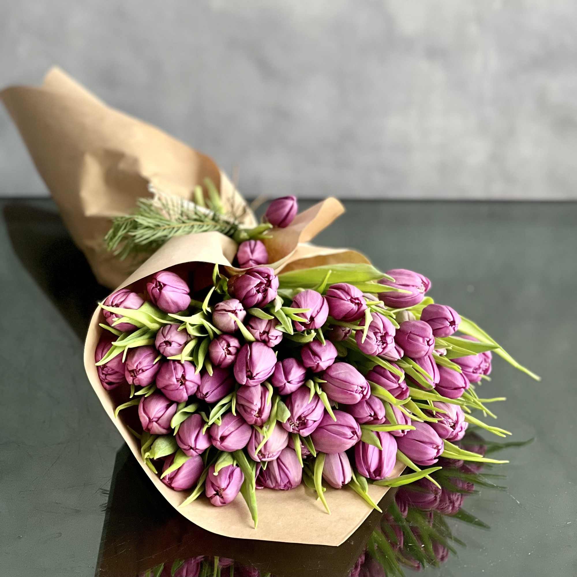 Bouquet of purple tulips wrapped in brown paper