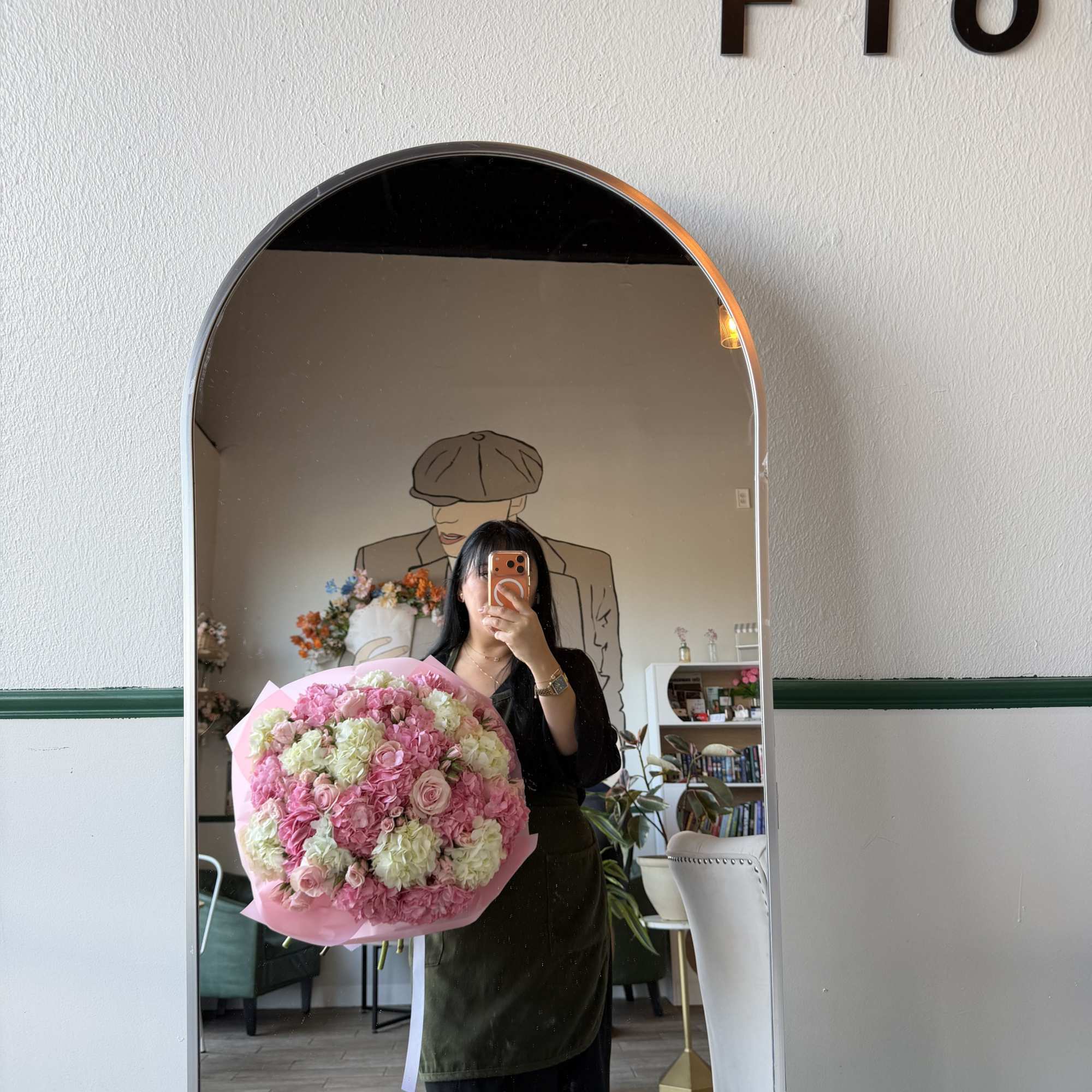 Large pink and white bouquet held in front of a mirror