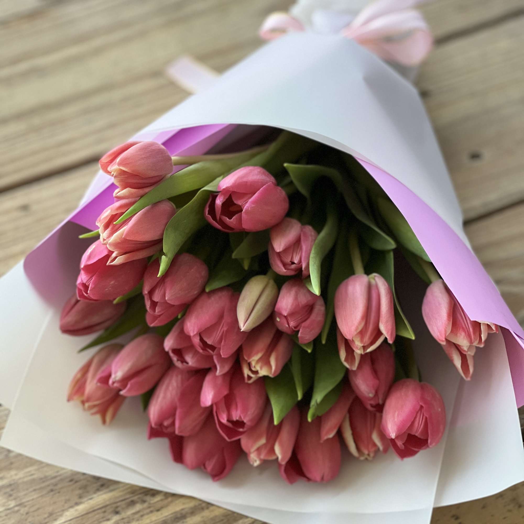 Bouquet of pink tulips wrapped in white and pink paper