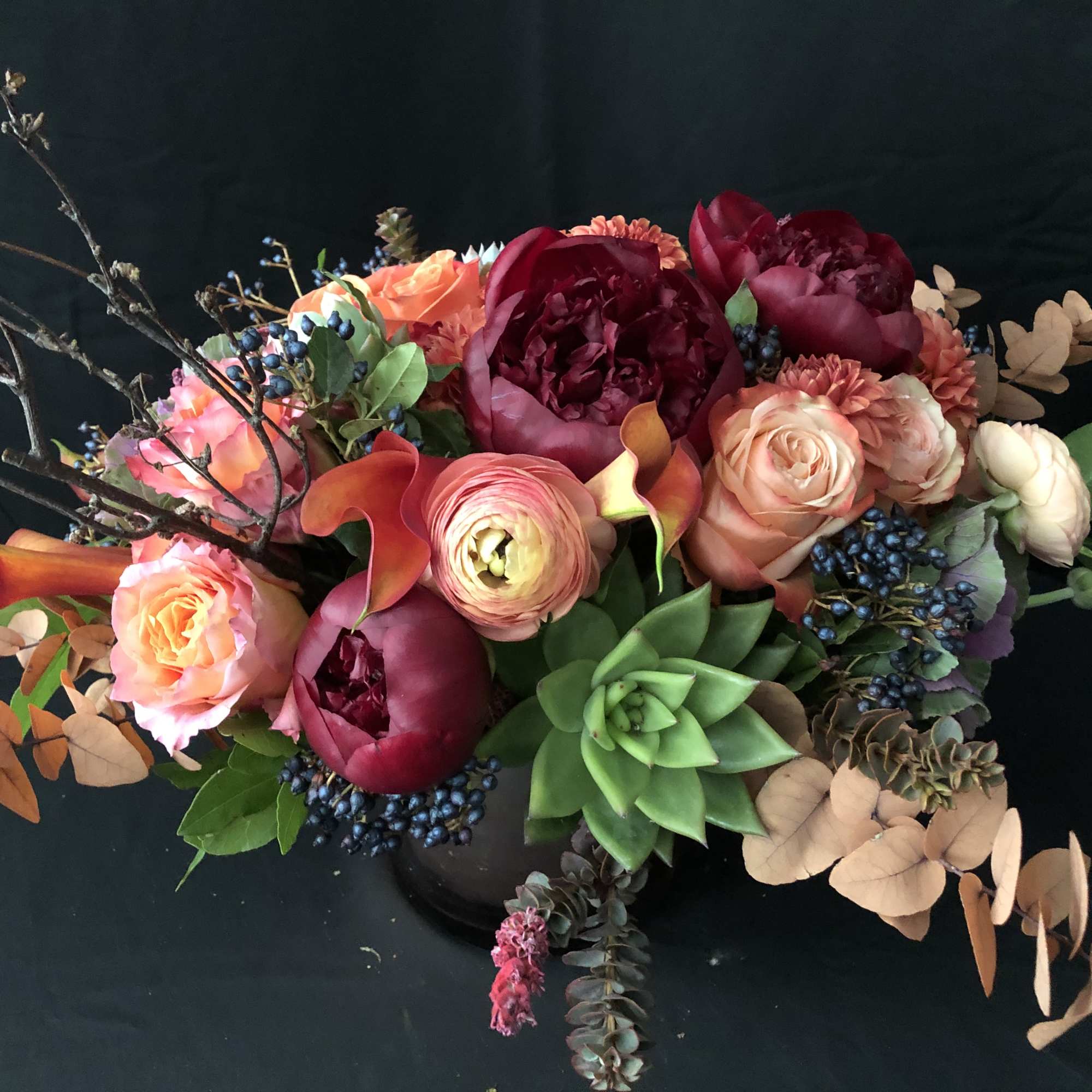 Mixed bouquet with pink and burgundy flowers and a green succulent